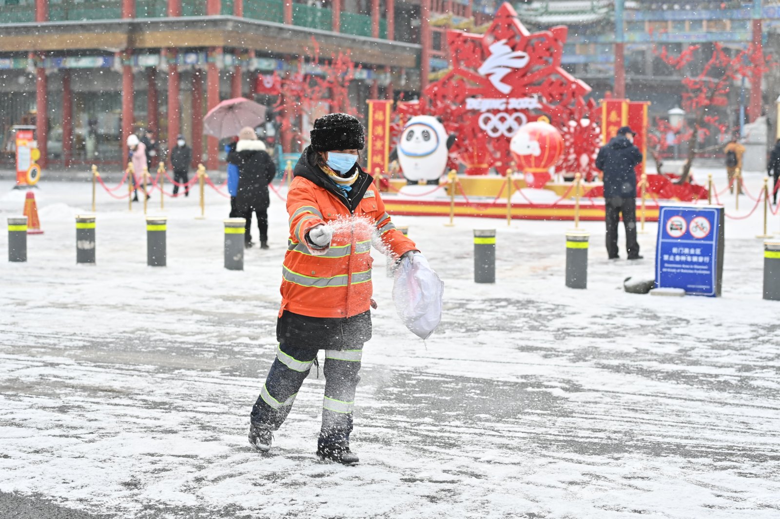 1月20日，在北京前門大街附近，環衞工人在撒融雪劑。（新華社）