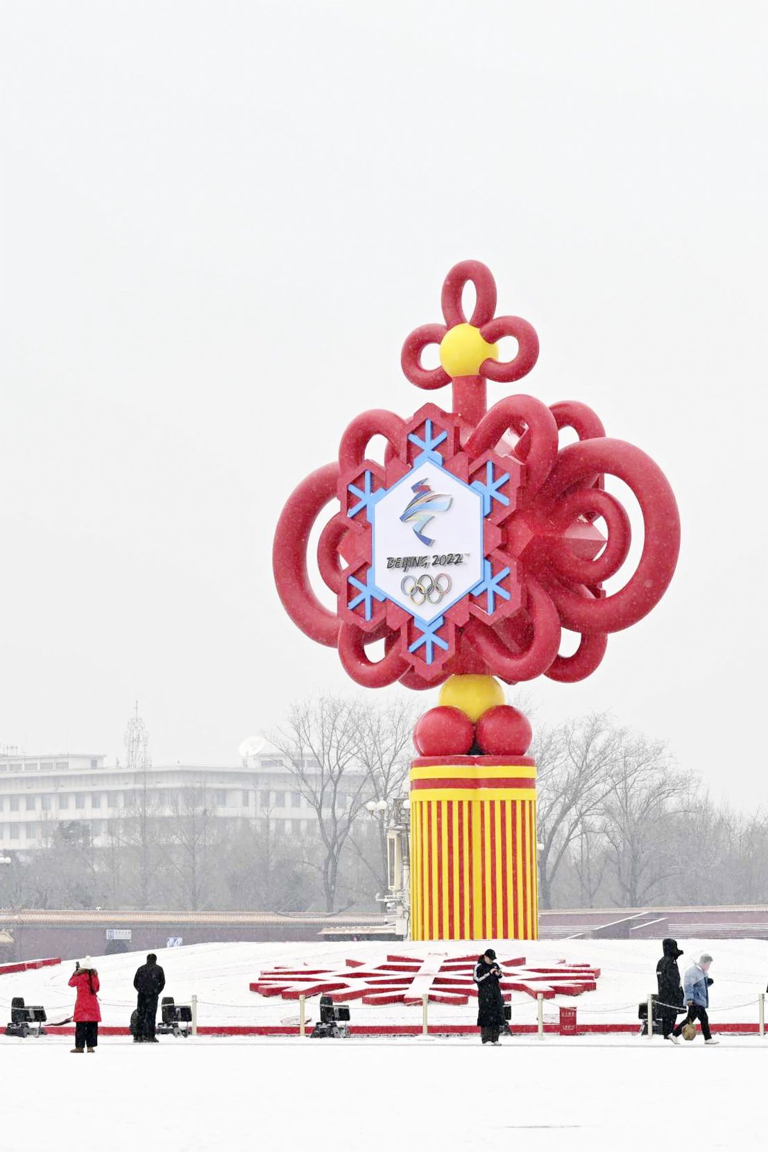1月20日，在北京前門大街，一對雙胞胎在父親的陪伴下在雪中玩耍。（新華社）