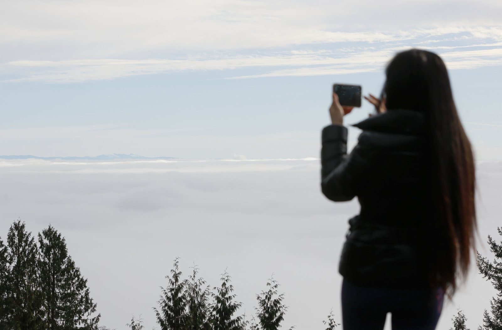 一名女子在加拿大的賽普里斯山上觀看大霧籠罩溫哥華市的景象。新華社