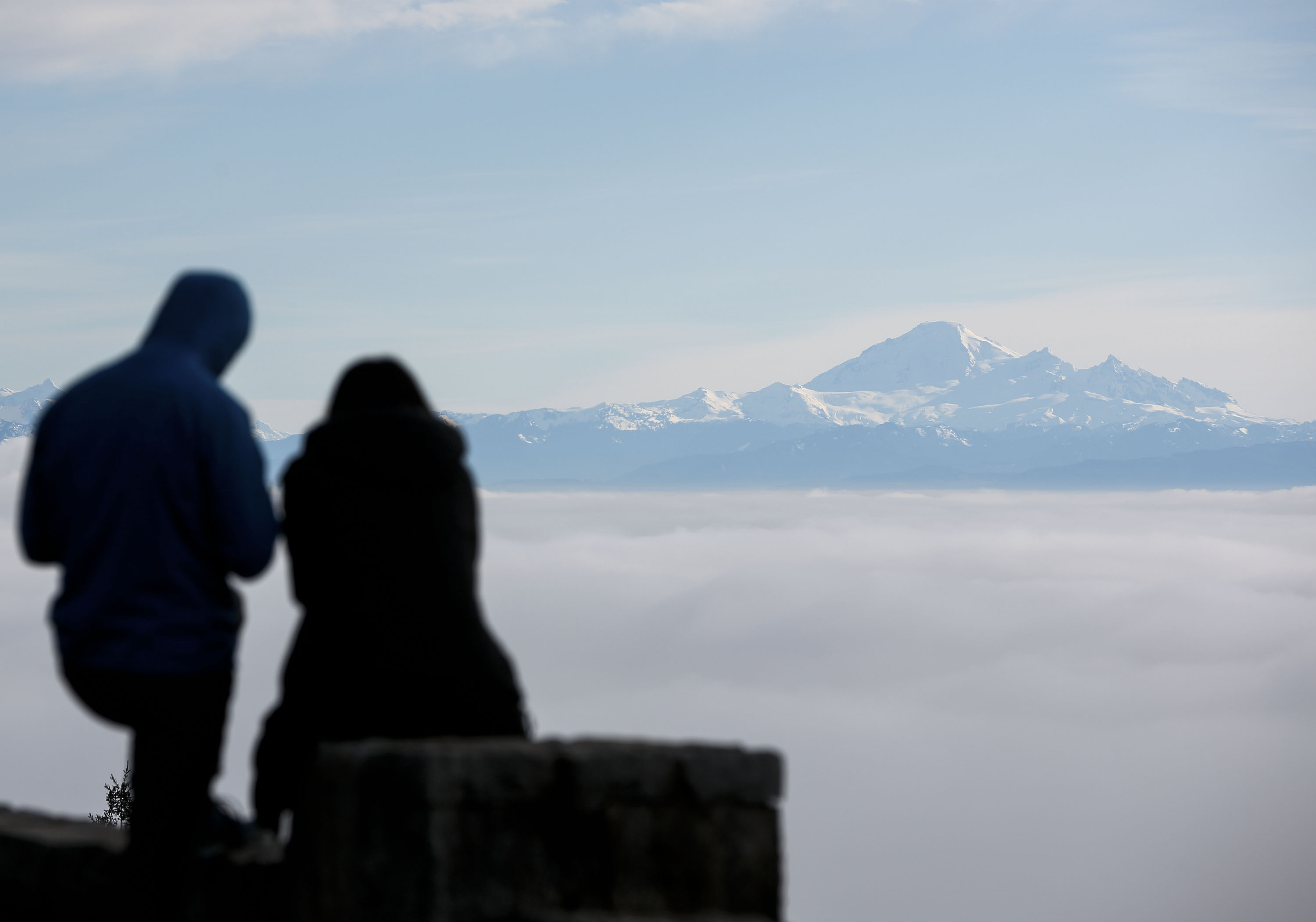人們在加拿大的賽普里斯山上觀看大霧籠罩溫哥華市的景象。新華社