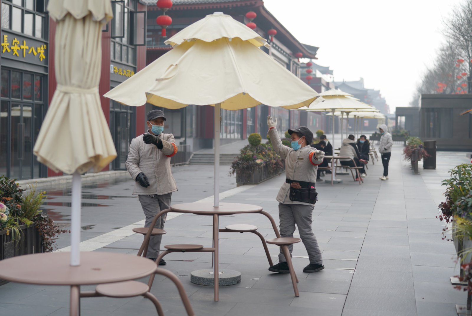 1月24日，在西安大唐不夜城，工作人員打開戶外遮陽傘。（新華社）