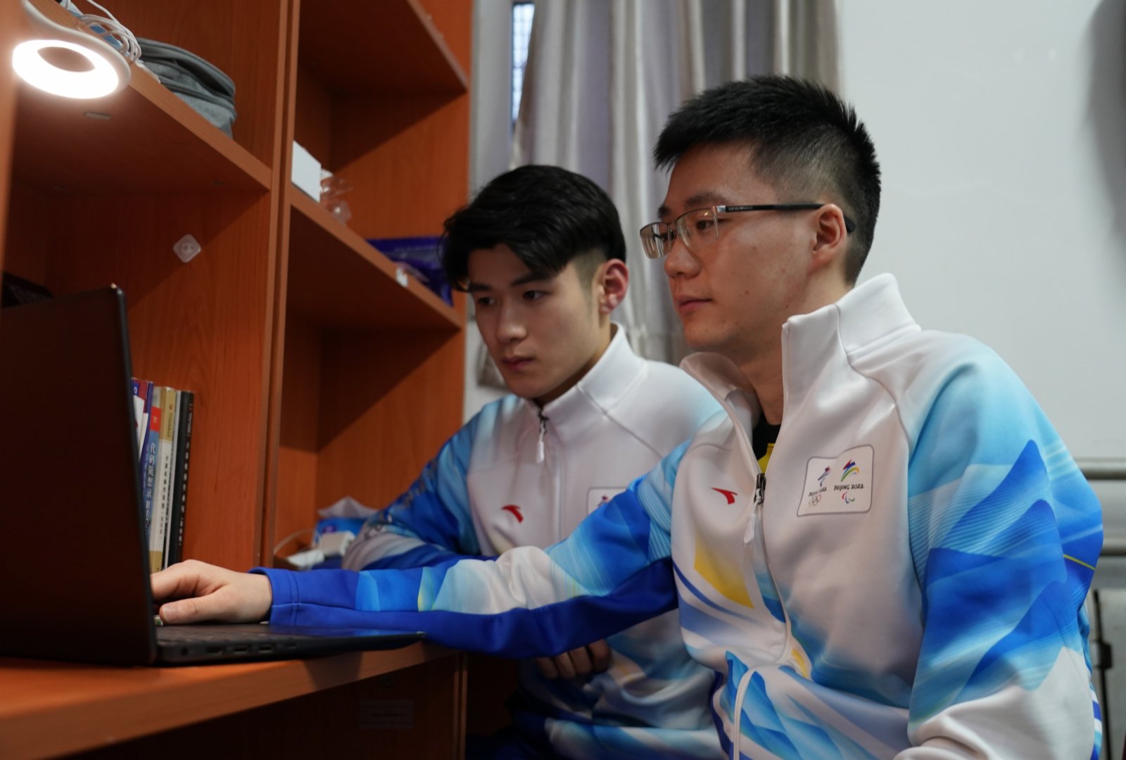 譚夏（右）與舍友王偉傑在宿舍線上學習冬奧培訓課程（1月20日攝）。（新華社）