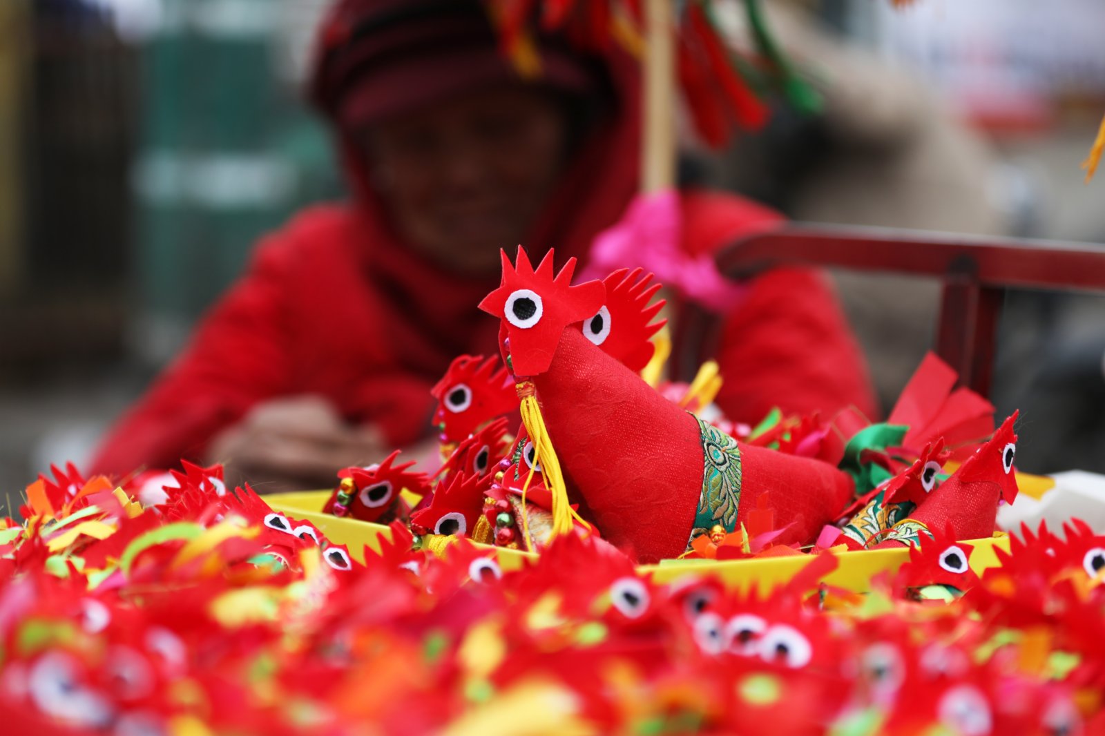 一名民間手工藝人在山東省臨沂市郯城縣街頭售賣自己縫製的「春雞」。新華社