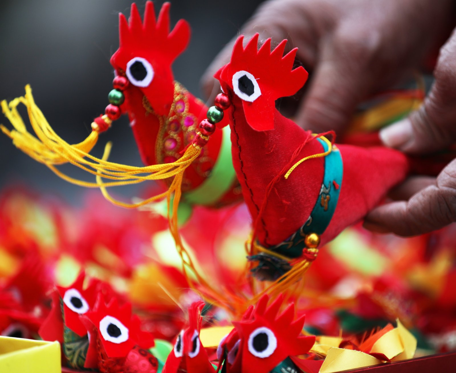 在山東省臨沂市郯城縣街頭，一名民間手工藝人展示自己縫製的「春雞」。新華社
