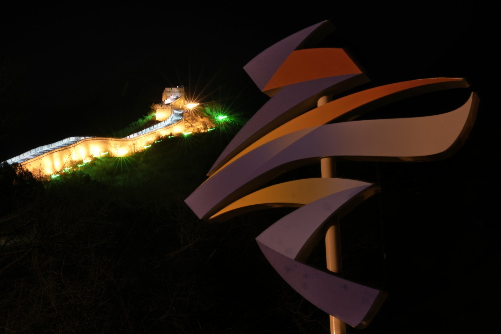夜晚的北京八達(dá)嶺長(zhǎng)城燈光璀璨，與山腳下的奧運(yùn)標(biāo)誌遙相呼應(yīng)。美聯(lián)社