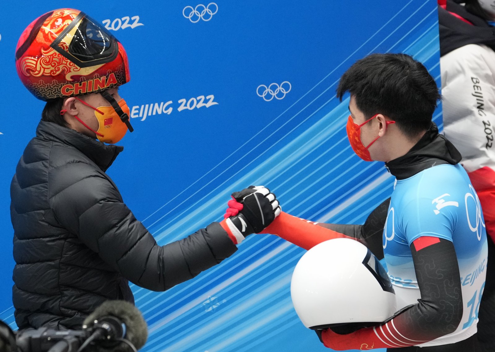 中國選手閆文港（右）在比賽後和隊友殷正握手。新華社