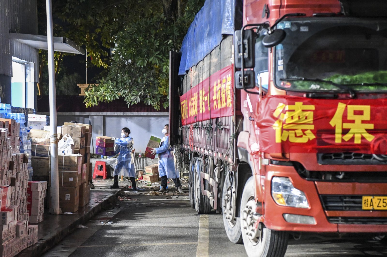 2月11日，工作人員在德保縣一處倉庫外搬運抗疫物資。（新華社）