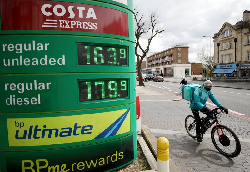 4月8日，一名送餐員騎車經過英國倫敦一處加油站。國際油價8日上漲。（新華社記者 李穎 攝）
