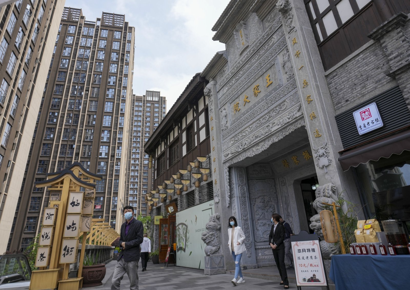 4月13日，遊客走過重慶南岸區彈子石老街修復後的老建築王家大院。（新華社）