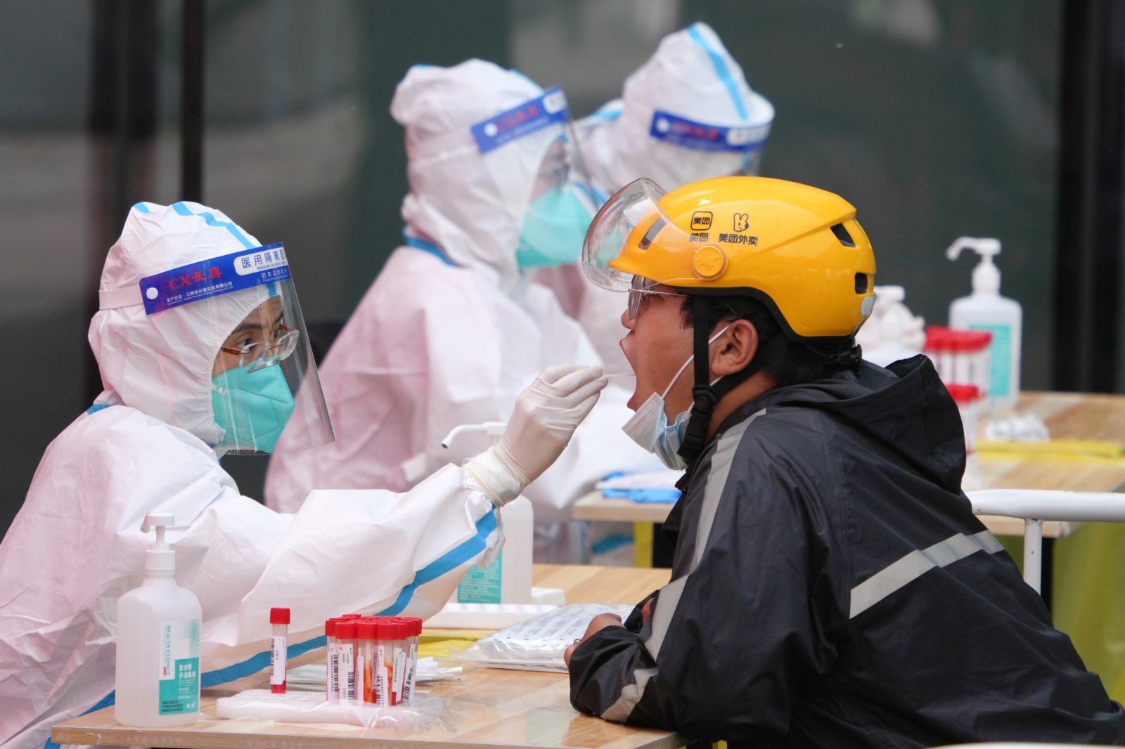 5月5日，在北京市朝陽區建外街道一處核酸檢測點，來自北京安貞醫院的醫務人員（左）在進行核酸採樣。新華社