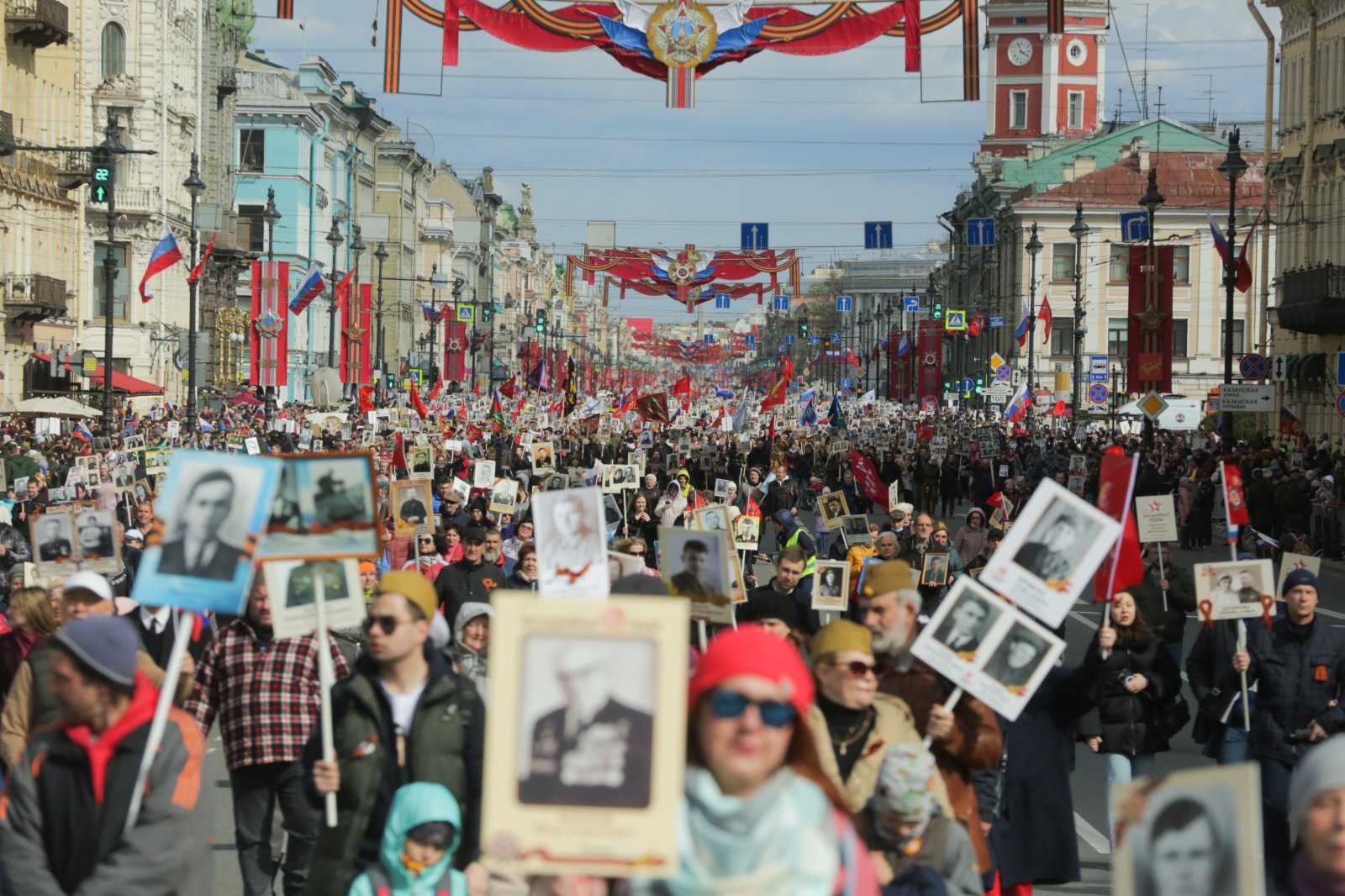 俄羅斯聖彼得堡民眾手持老戰士的照片或畫像參加「不朽軍團」遊行。（新華社）