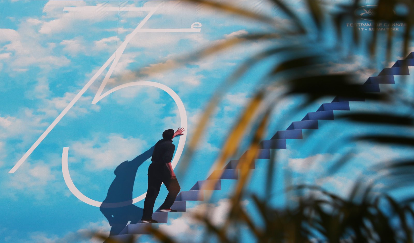 法國戛納電影宮外的棕櫚樹葉和電影節巨幅海報。（新華社）