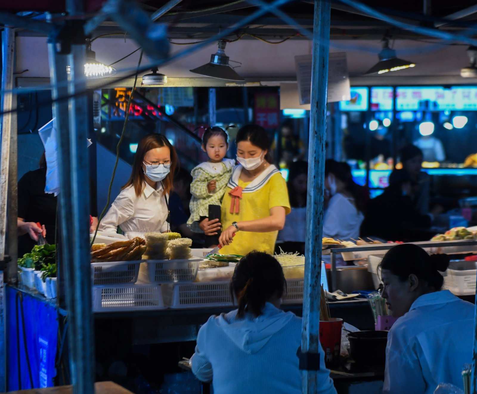5月17日，居民在濮院鎮佳源夜市的小吃攤挑選美食。（新華社）