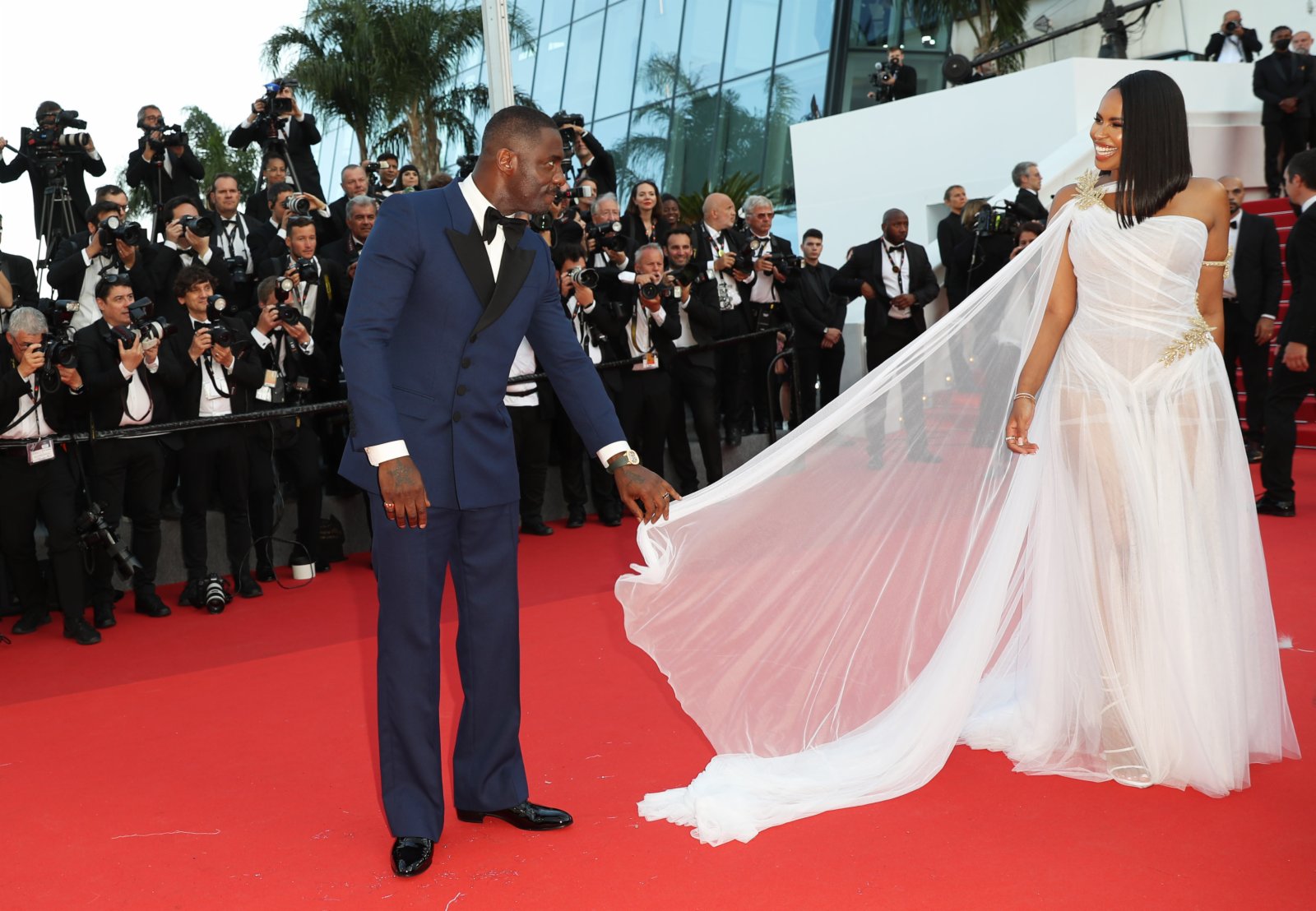 5月20日，在法國戛納舉行的第75屆戛納國際電影節上，演員伊德瑞斯·艾爾巴（左）和妻子抵達影片《三千年的渴望》首映式現場。（新華社）