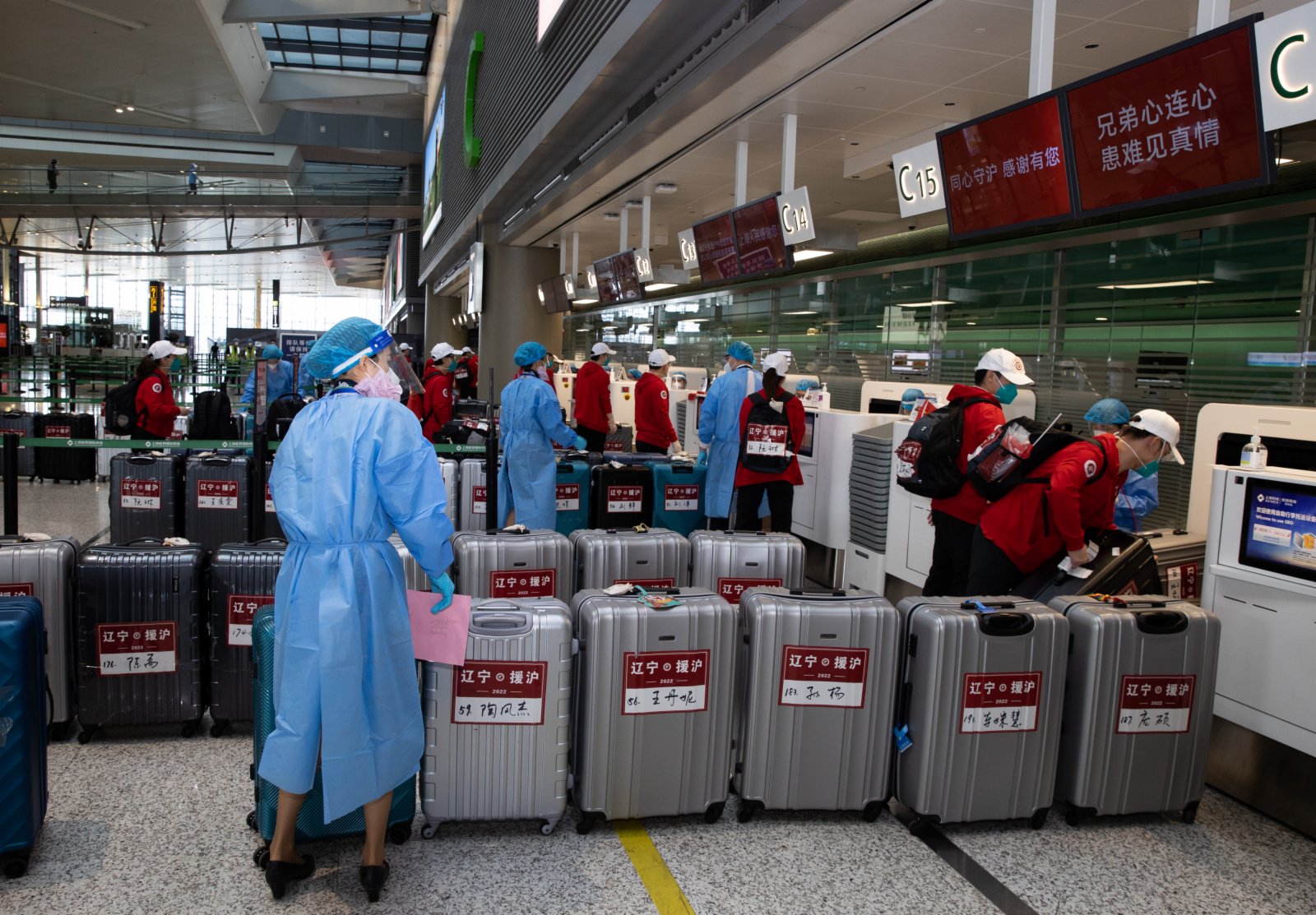 5月21日，在上海虹橋國際機場，工作人員幫助遼寧省援滬醫療隊隊員托運行李。（新華社）