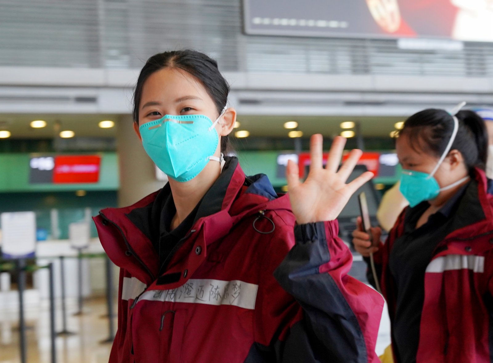 5月23日，在上海虹橋國際機場，一名海南援滬醫療隊隊員向送行人員揮手道別。