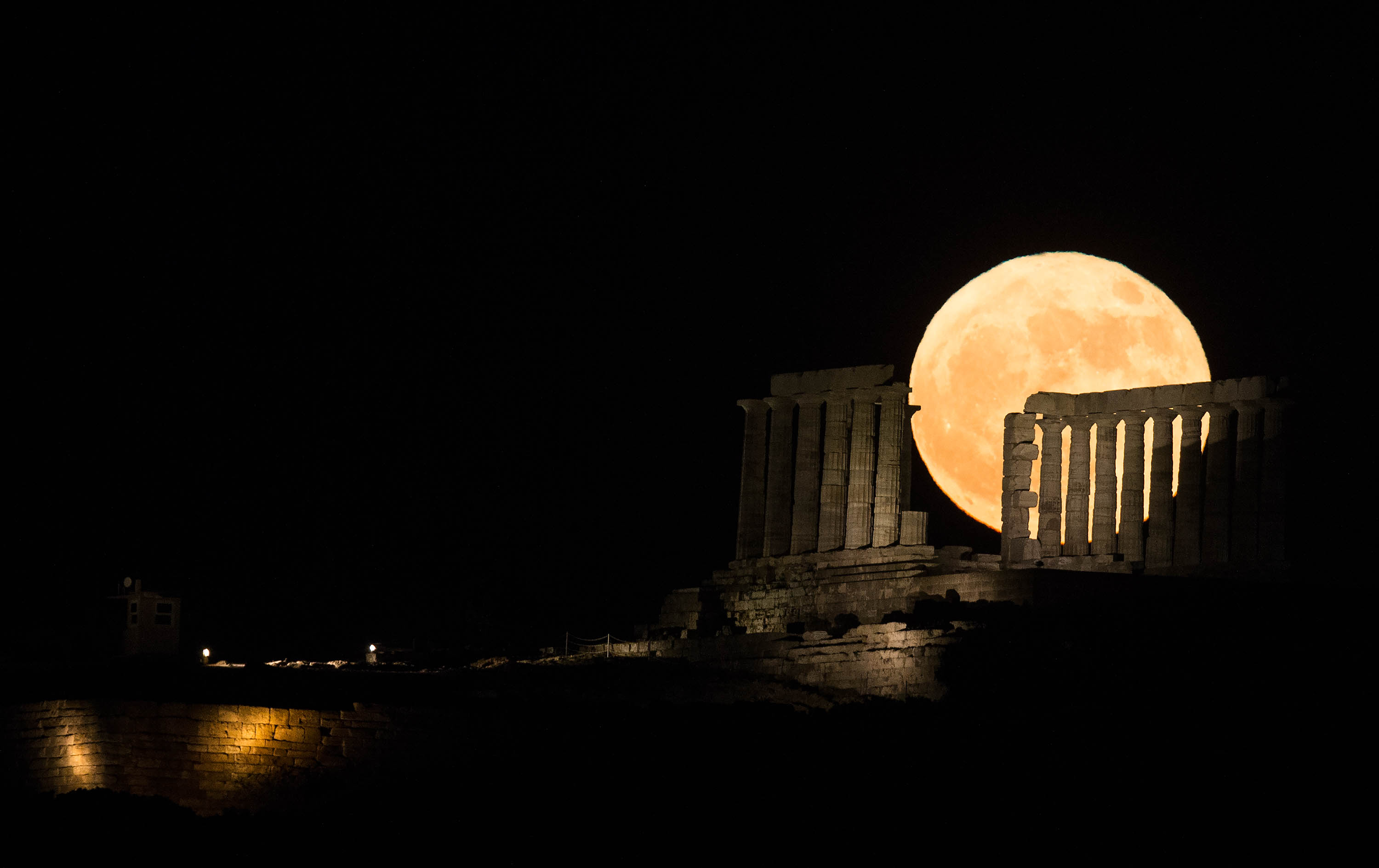 6月14日，「超級月亮」從希臘雅典附近蘇尼翁角的波塞冬神廟後方升起。（新華社）