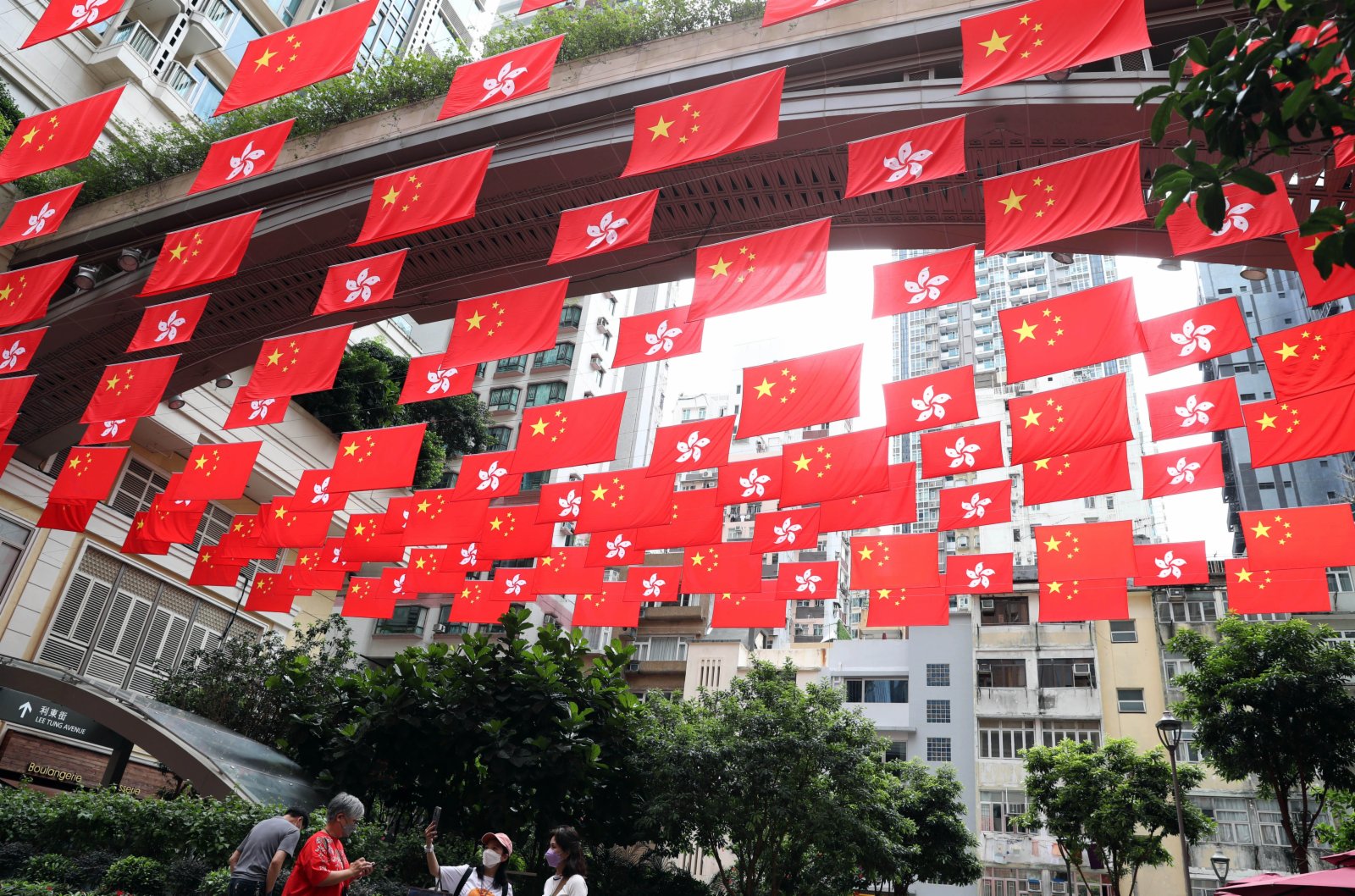 在香港利東街，中華人民共和國國旗和香港特別行政區區旗迎風飄揚。（新華社）
