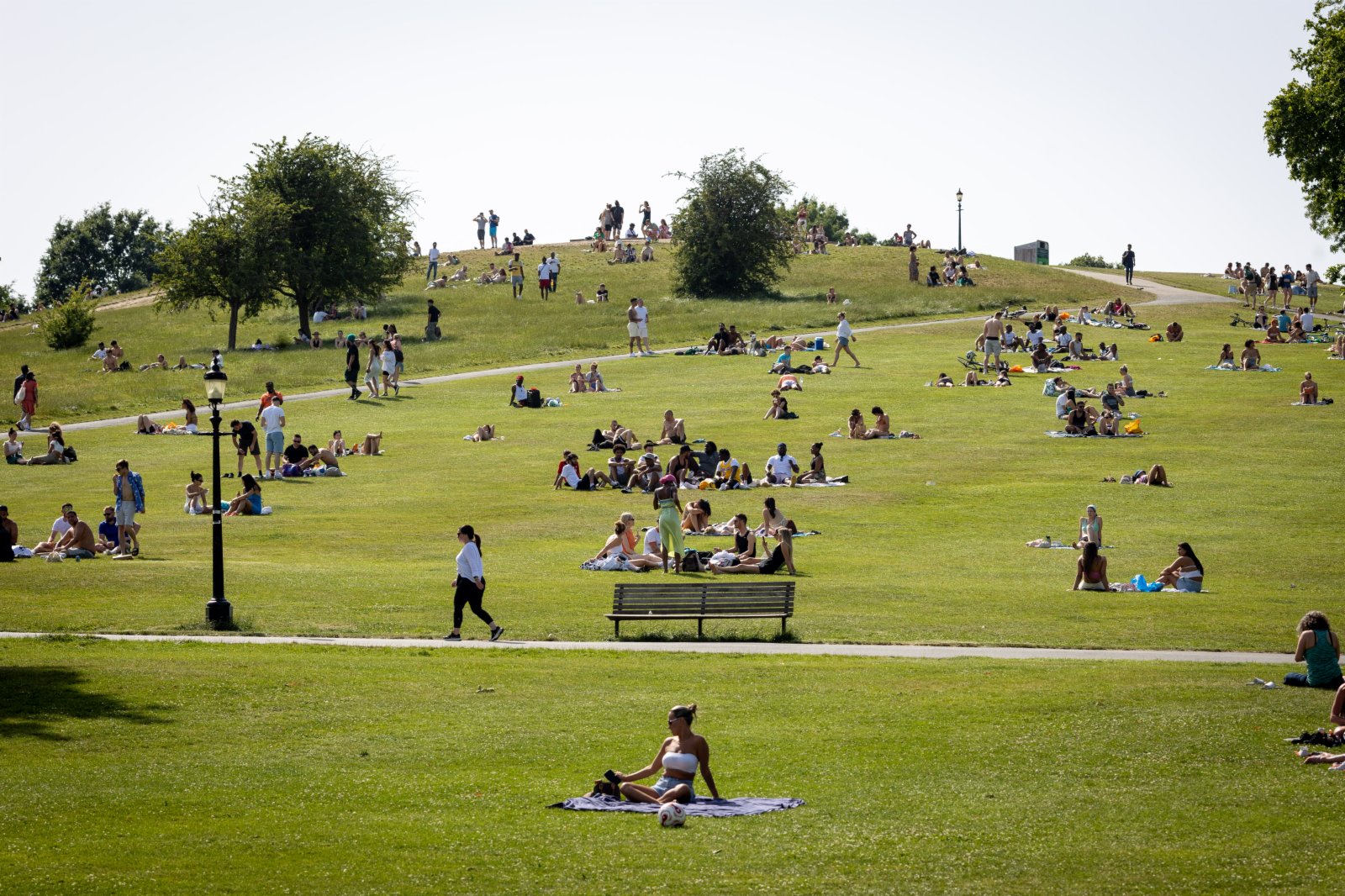 6月17日，人們在英國倫敦一處山坡上享受陽光。（新華社）