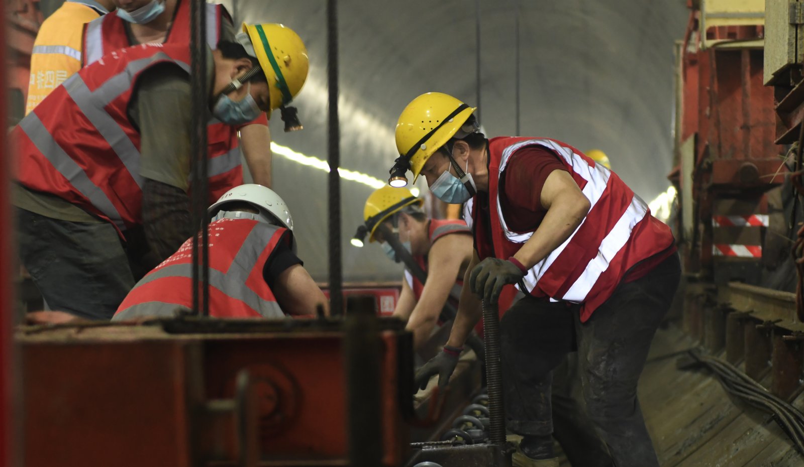6月20日，最後一組軌排鋪設到位，中鐵四局的工人們在進行調整施工。（新華社）