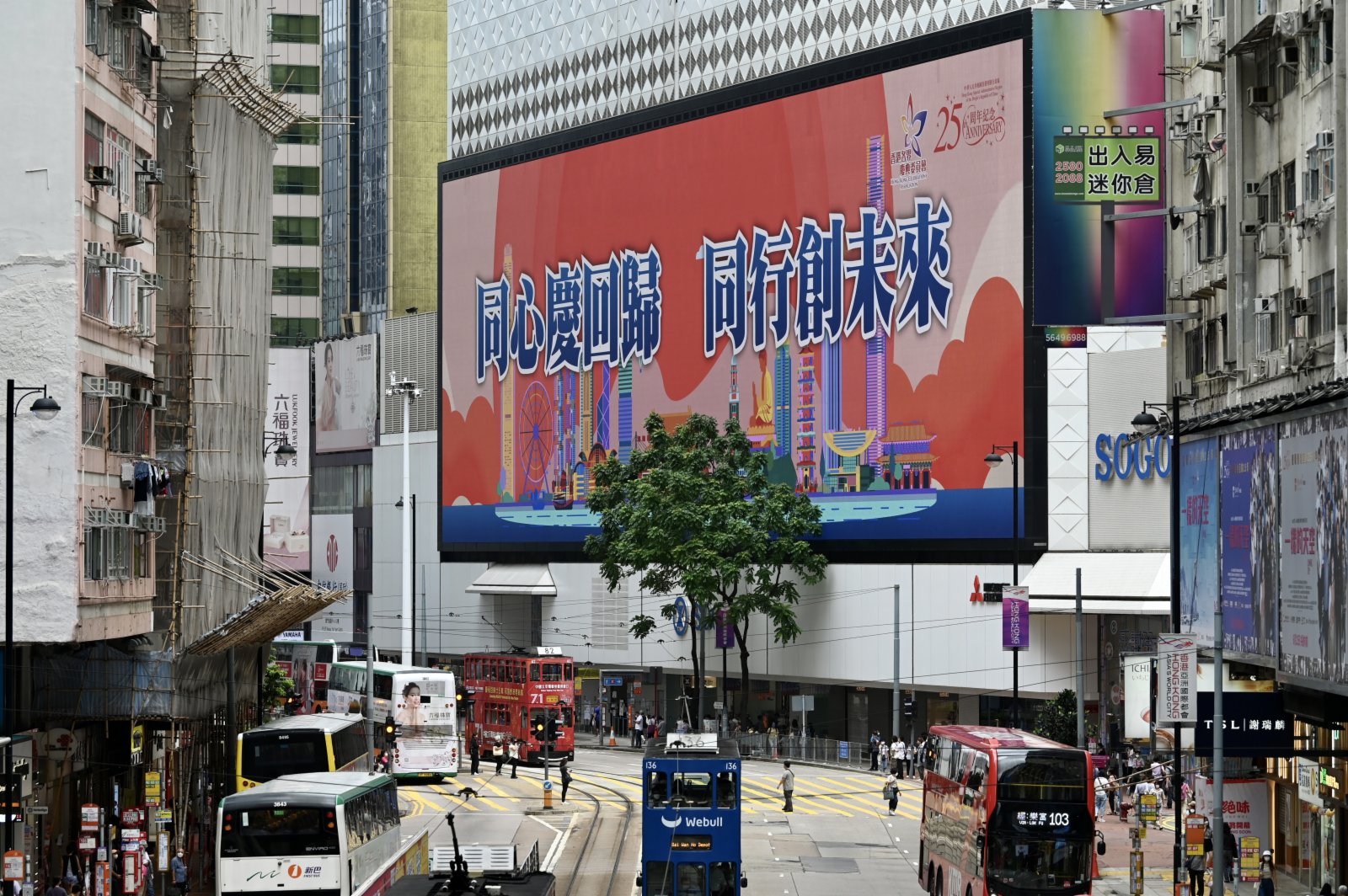 6月20日，香港街頭有展示慶祝香港回歸祖國25周年的海報。圖為銅鑼灣街頭的大屏幕播放慶回歸25周年廣告。 （中新社）