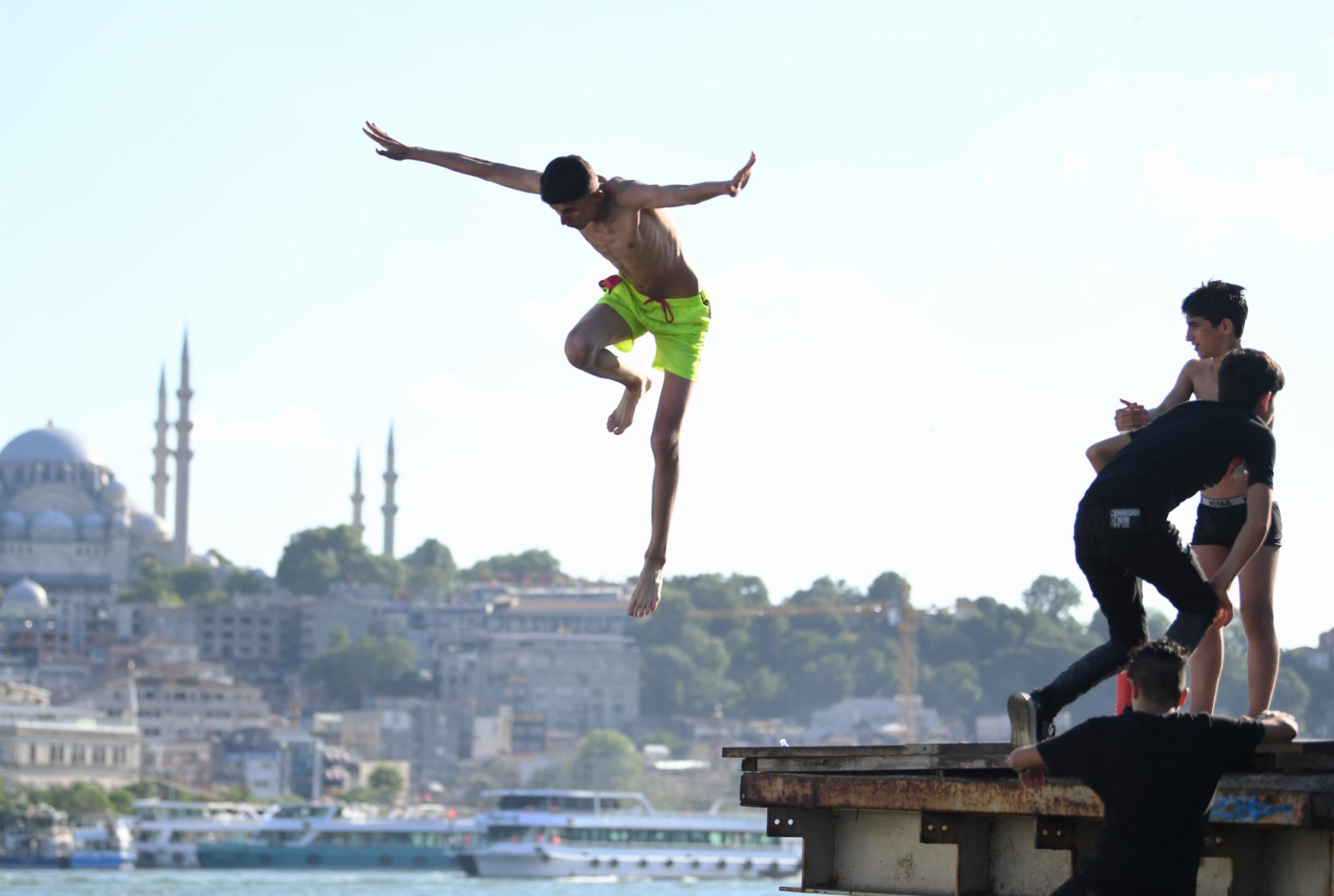 一名男子跳入土耳其伊斯坦布爾的博斯普魯斯海峽游泳。（新華社）