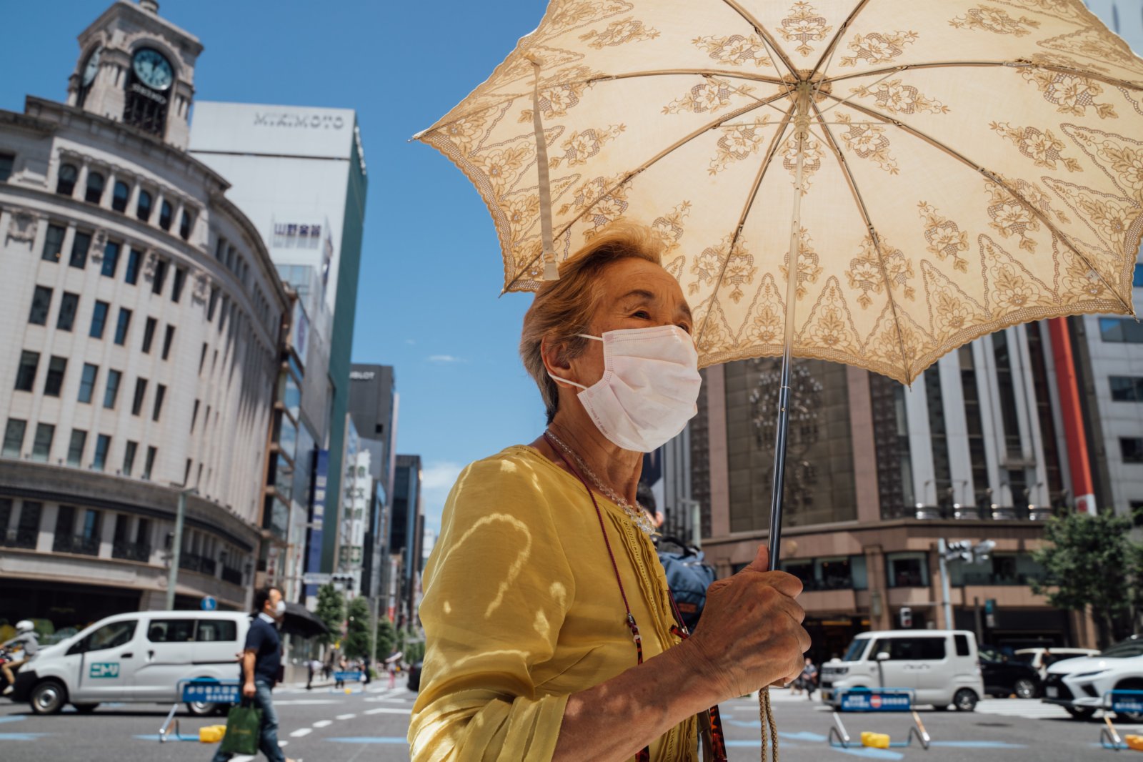 6月26日，行人打着遮陽傘走過日本東京銀座街頭。（新華社）