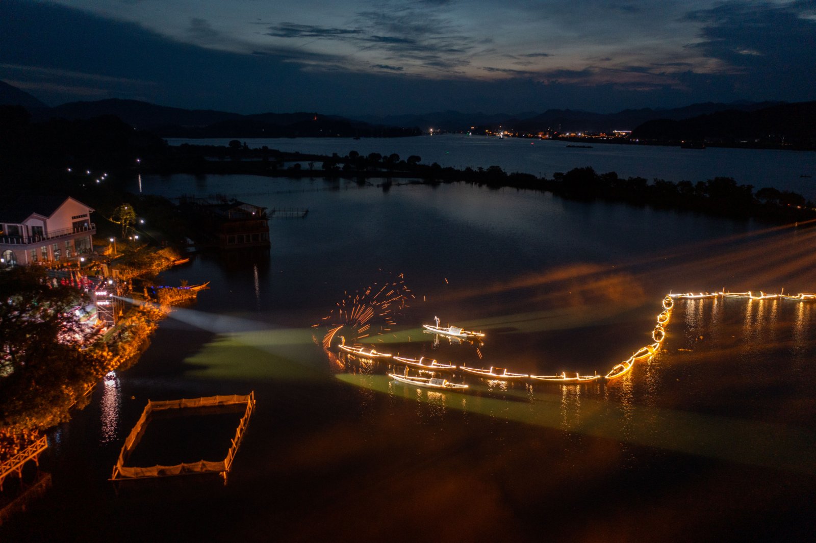 7月3日，三都漁村旁的江面上船隊船燈亮起，工作人員在船頭進行「漁火」煙花表演（無人機照片）。（新華社）