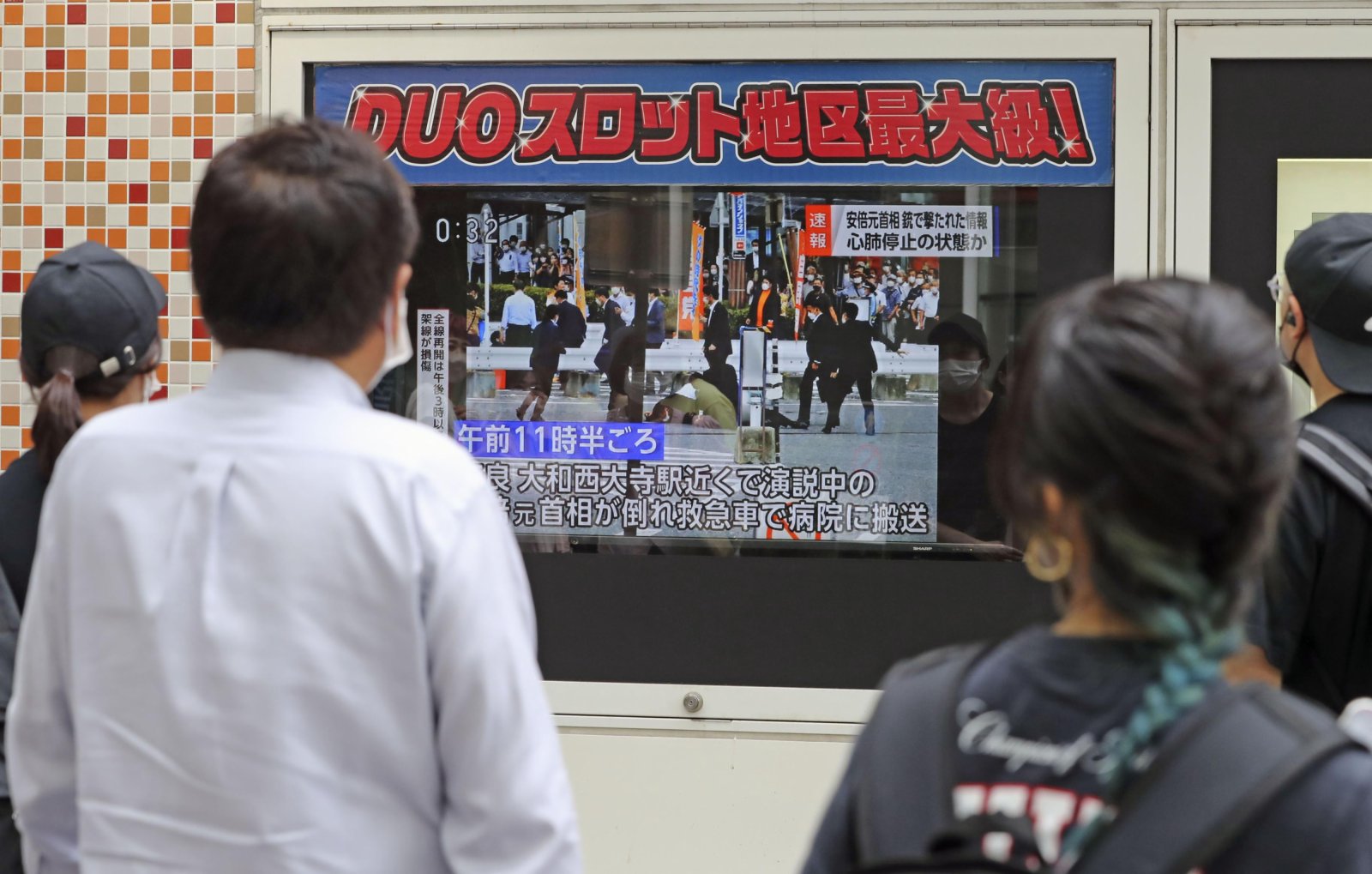 人們觀看電視新聞報道日本前首相安倍晉三被槍殺的事件。（美聯社）