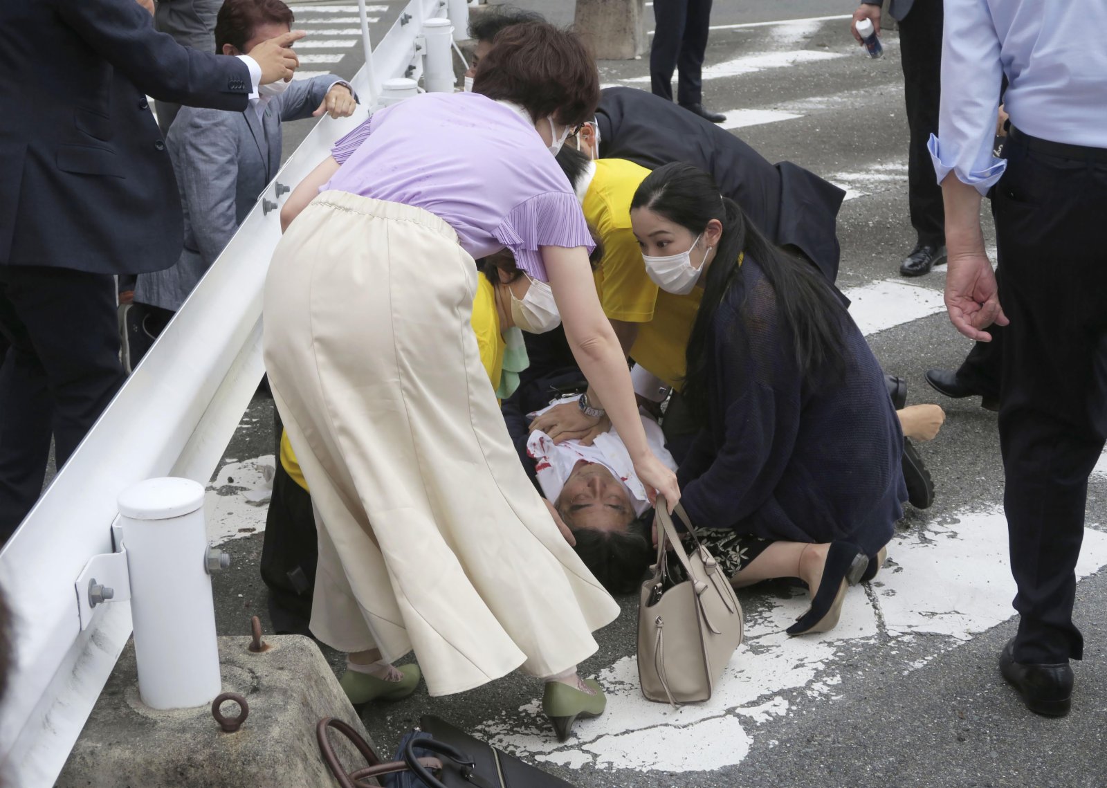 日本前首相安倍晉三被槍擊後躺在地上且流血不止。（美聯社）