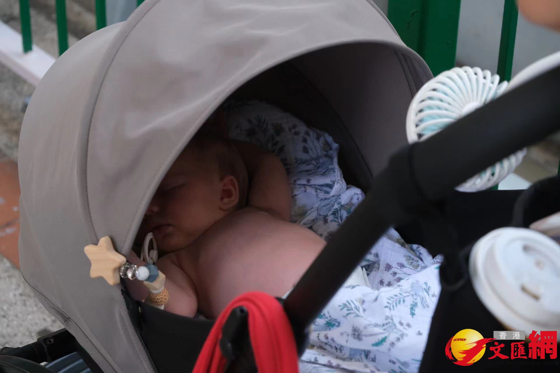 嬰兒車上掛着電風扇為小朋友吹風。 嬰兒車上掛着電風扇為小朋友吹風。