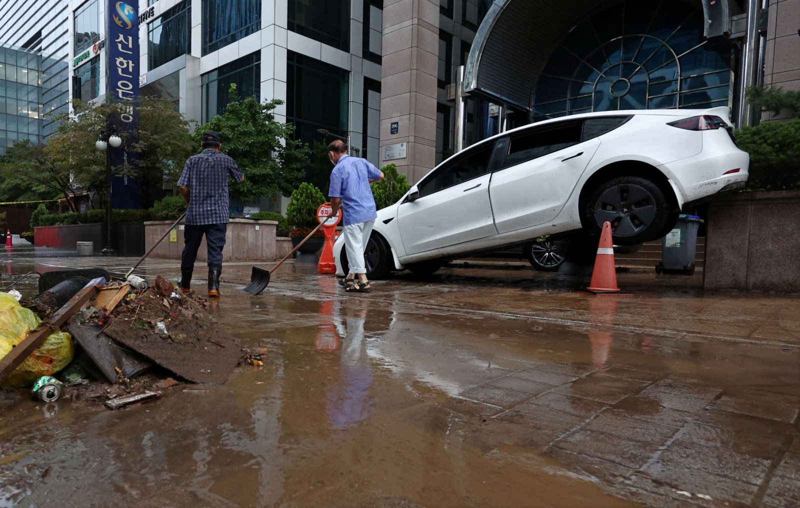 圖為8月9日，首爾江南區街道上被洪水沖毀的汽車。（法新社）
