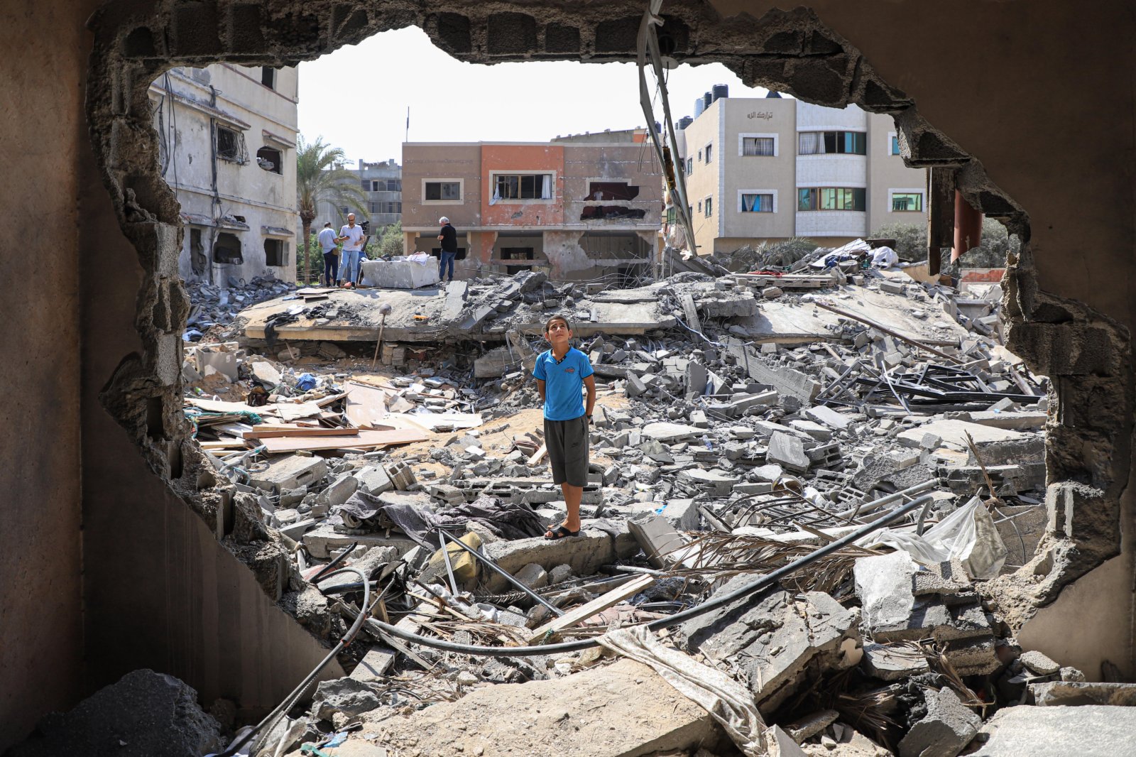 8月9日，在加沙城，一名男孩站在空襲後自家房屋的廢墟上。（新華社）