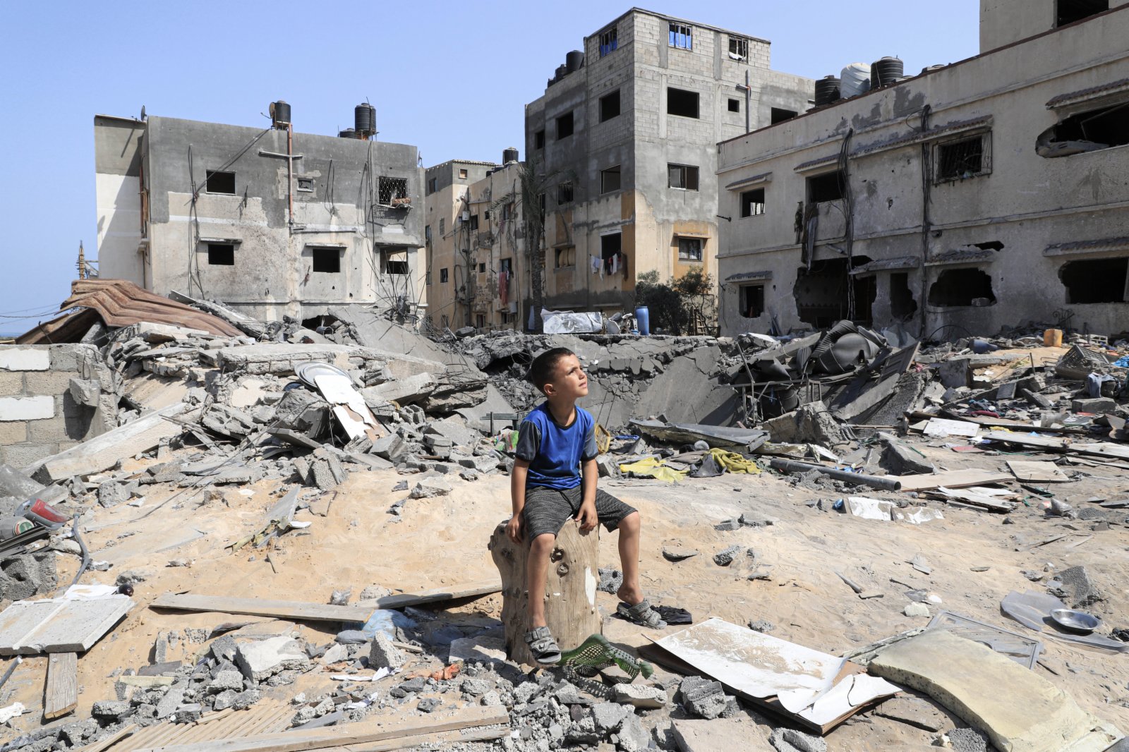 8月9日，在加沙城，一名男孩坐在空襲後自家房屋的廢墟上。（新華社）