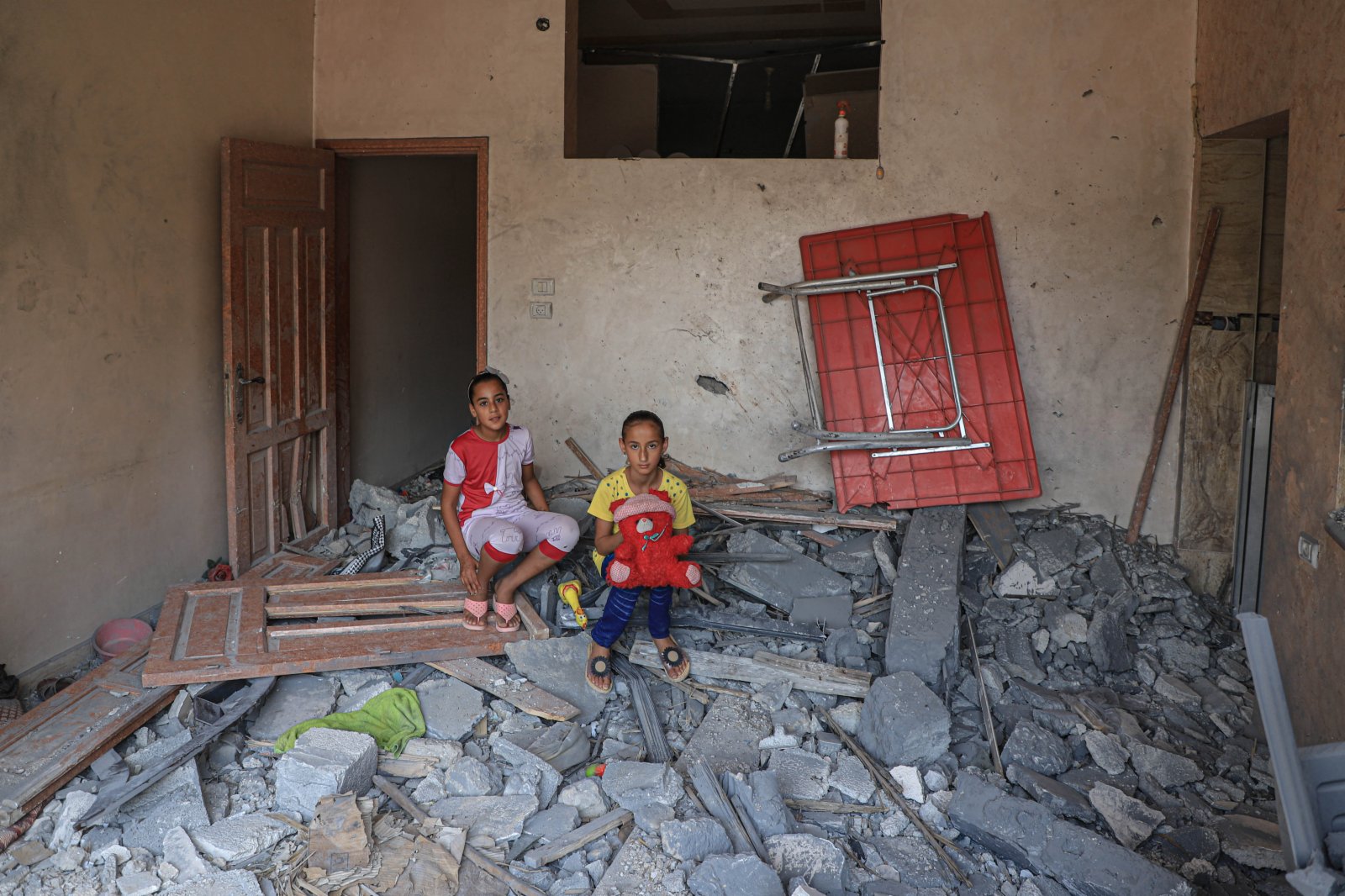 8月9日，在加沙城，兩名女孩坐在自家房屋內。（新華社）