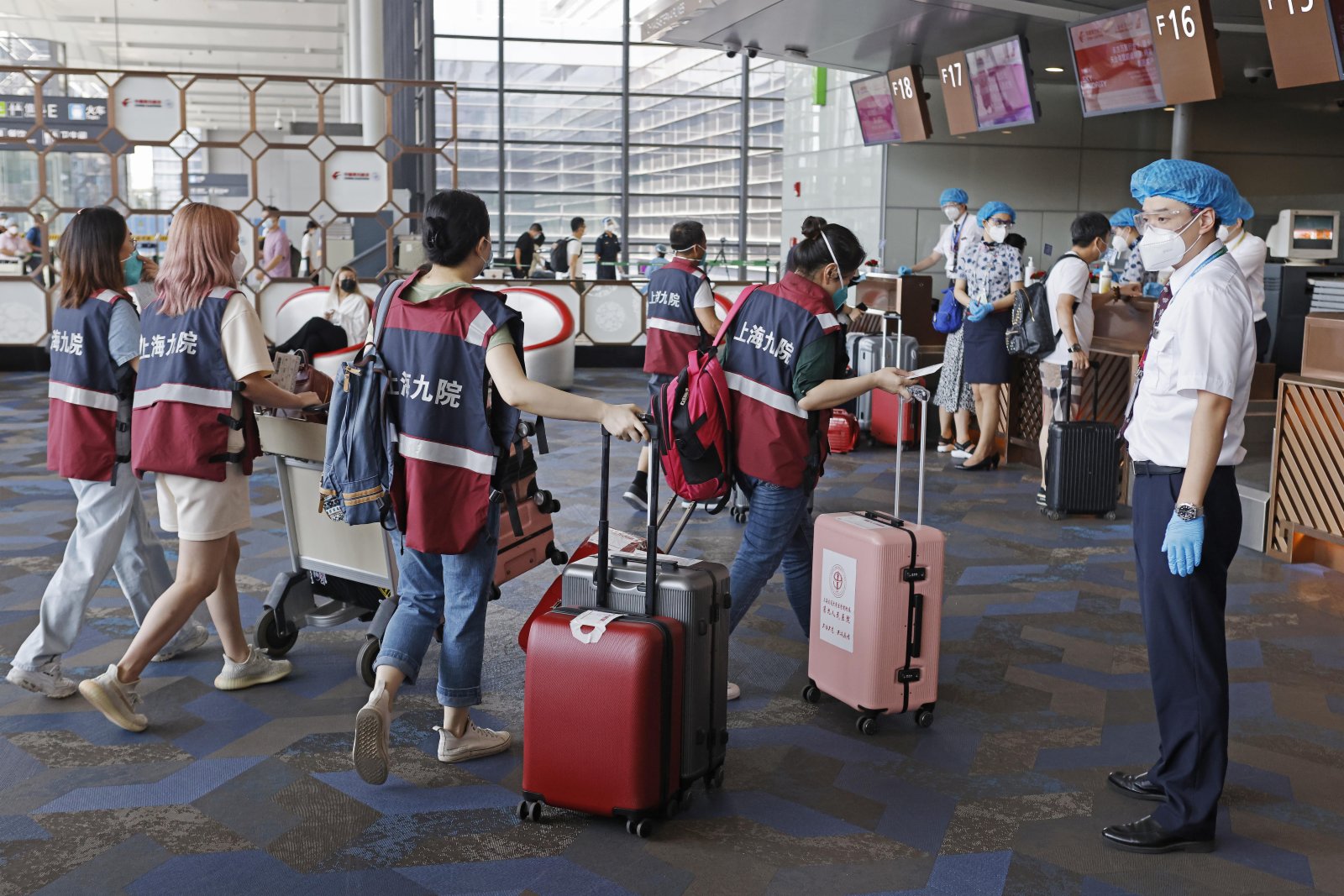 8月14日，上海虹橋機場內，醫療隊隊員準備辦理登機手續。（中新社）