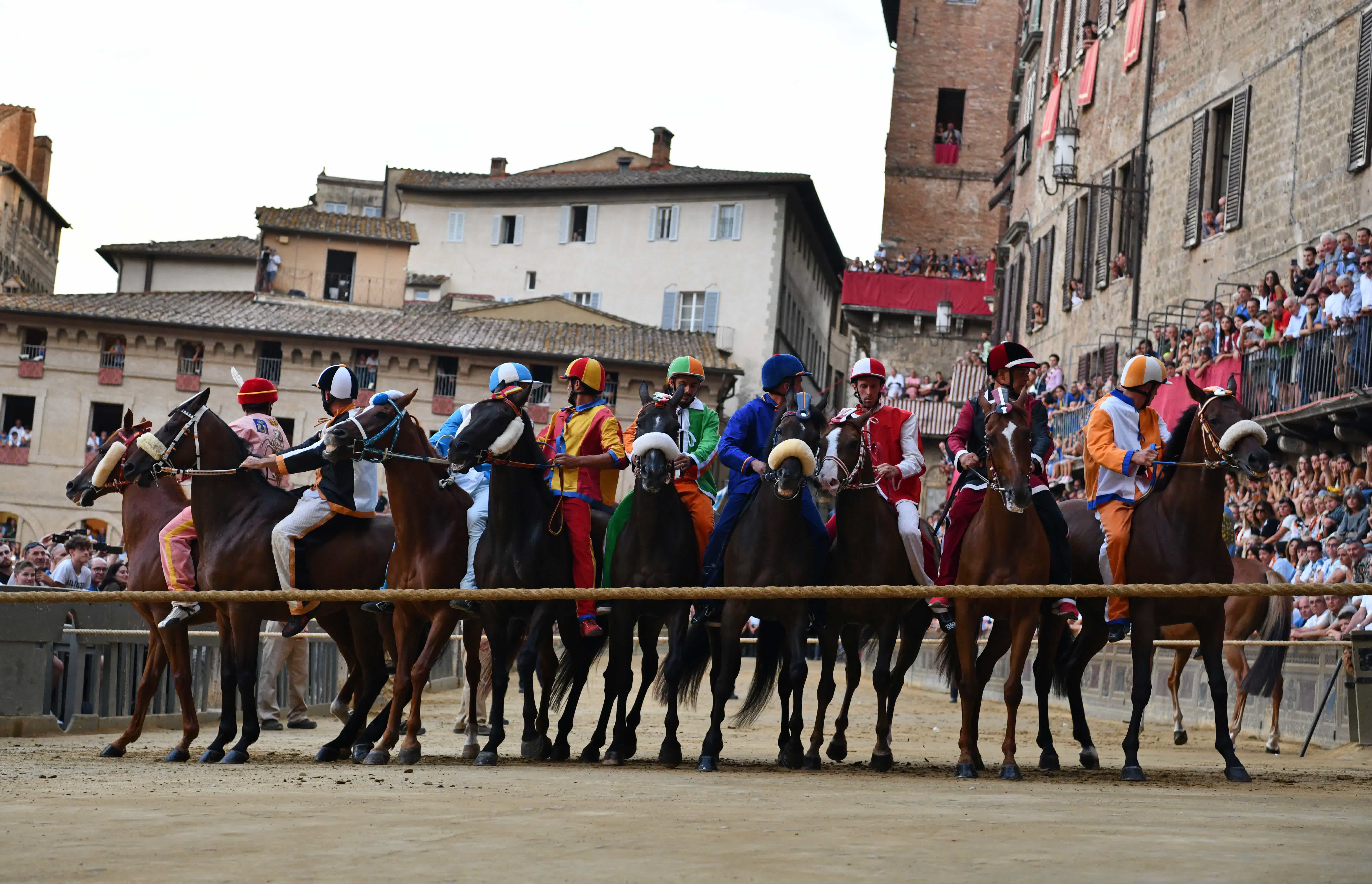 8月15日，騎手在意大利錫耶納田野廣場上參加賽馬節熱身賽。新華社