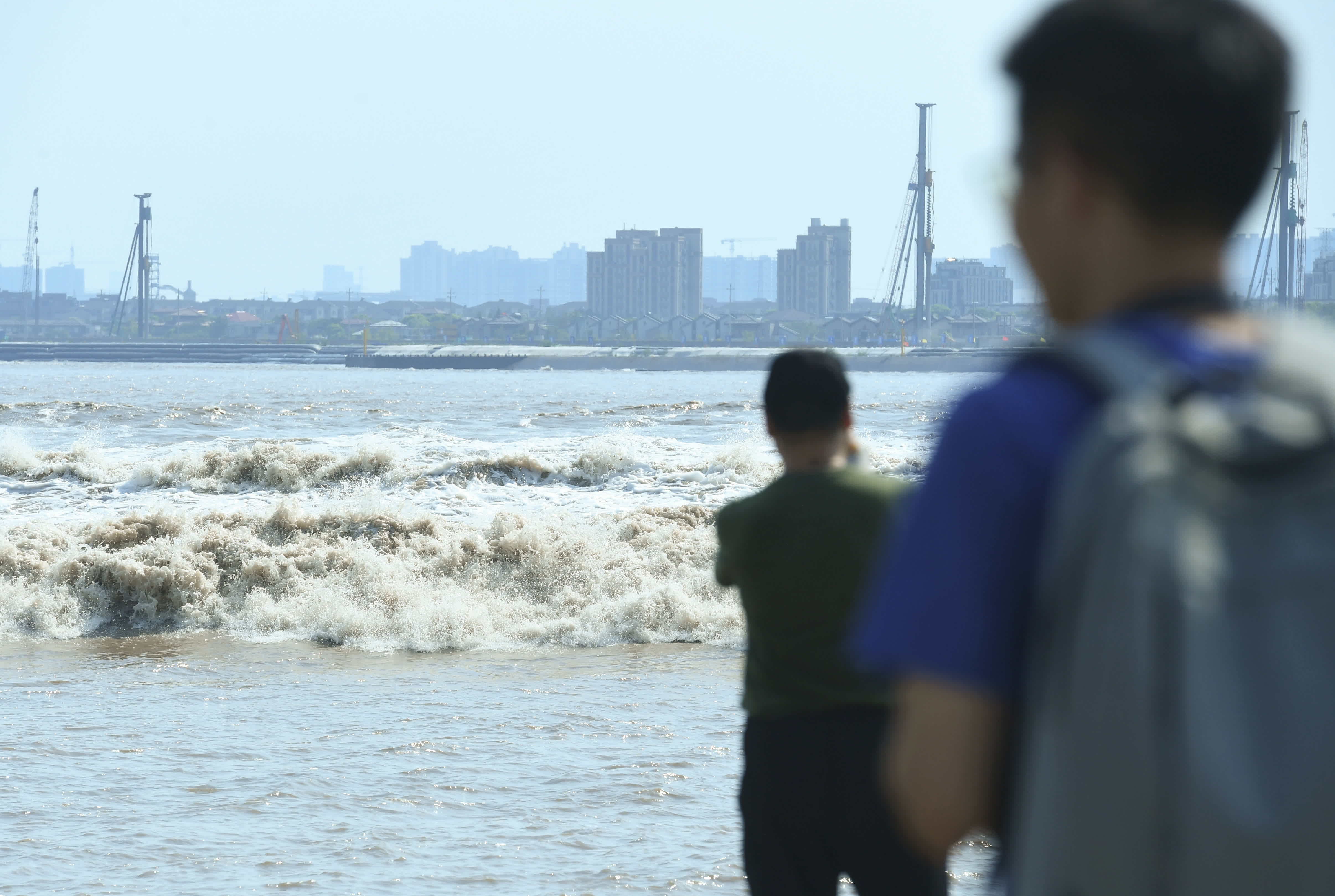 8月15日，浙江嘉興，遊客在觀賞錢塘江回頭潮。中新社