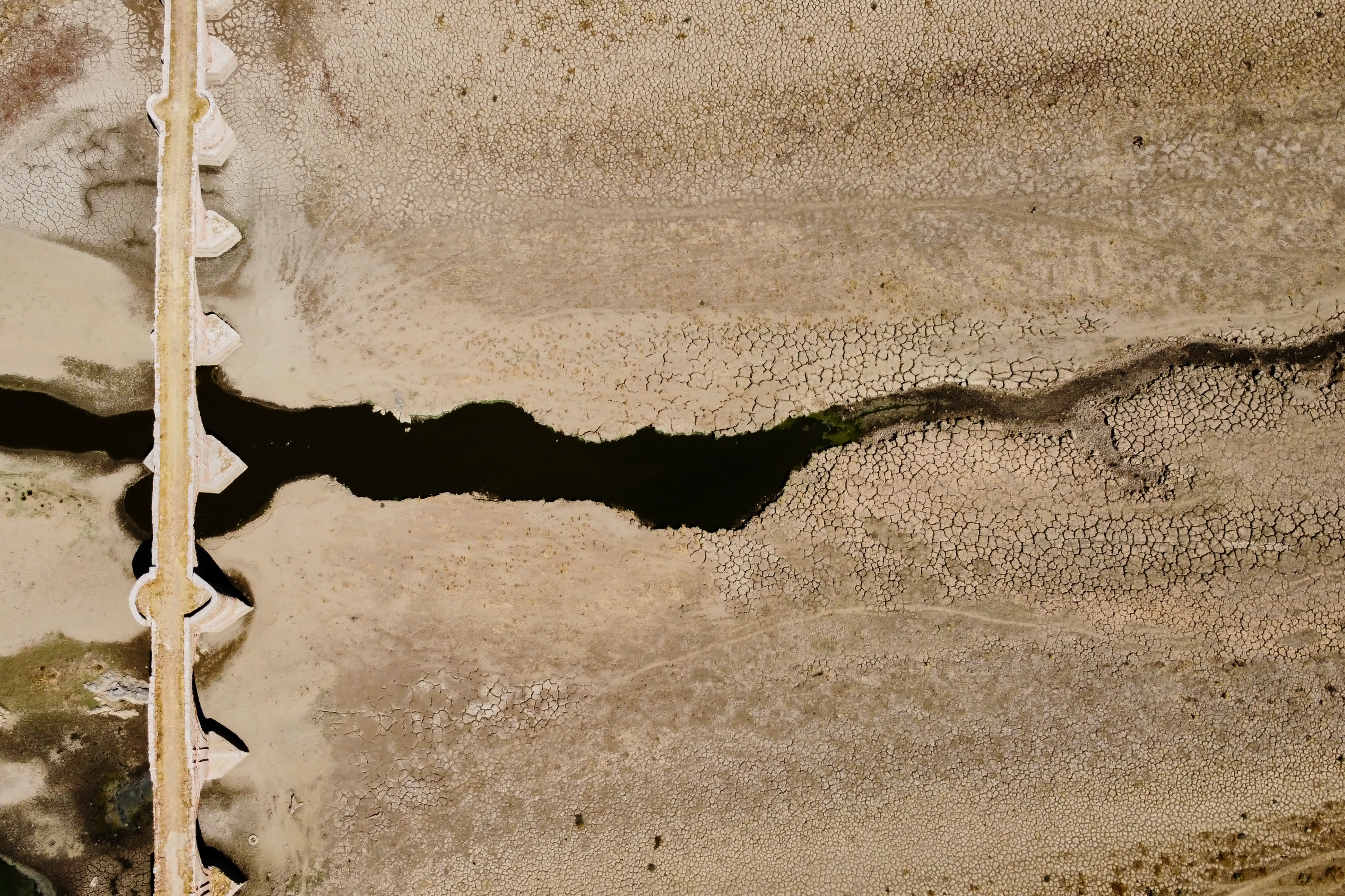 這是8月15日用無人機拍攝的乾涸的西班牙錫哈拉水庫，上世紀50年代因水庫落成而被淹沒的梅斯塔古橋重見天日。（新華社）
