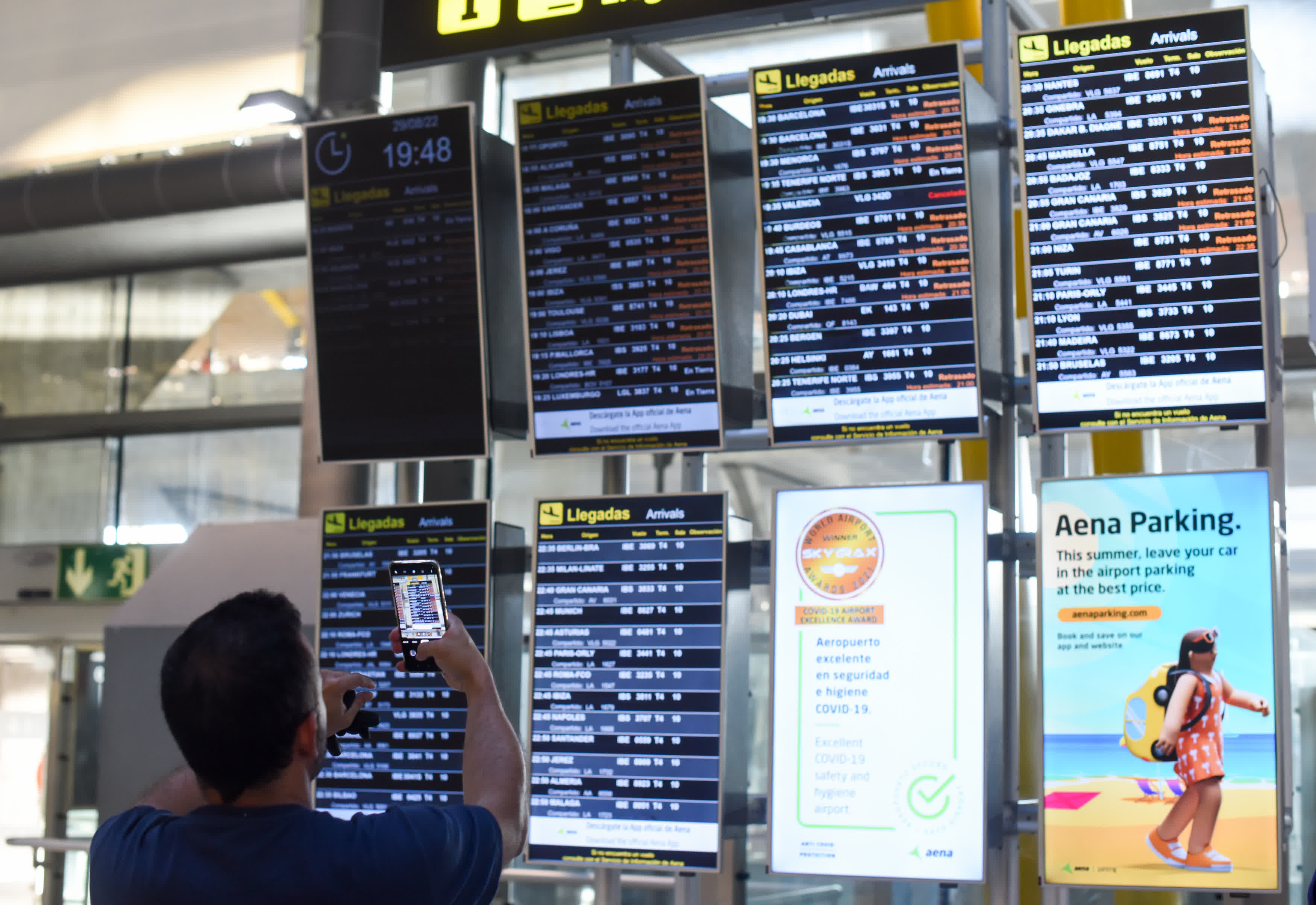 8月29日，一名男子在西班牙馬德里巴拉哈斯機場拍攝航班信息公告牌。（新華社）