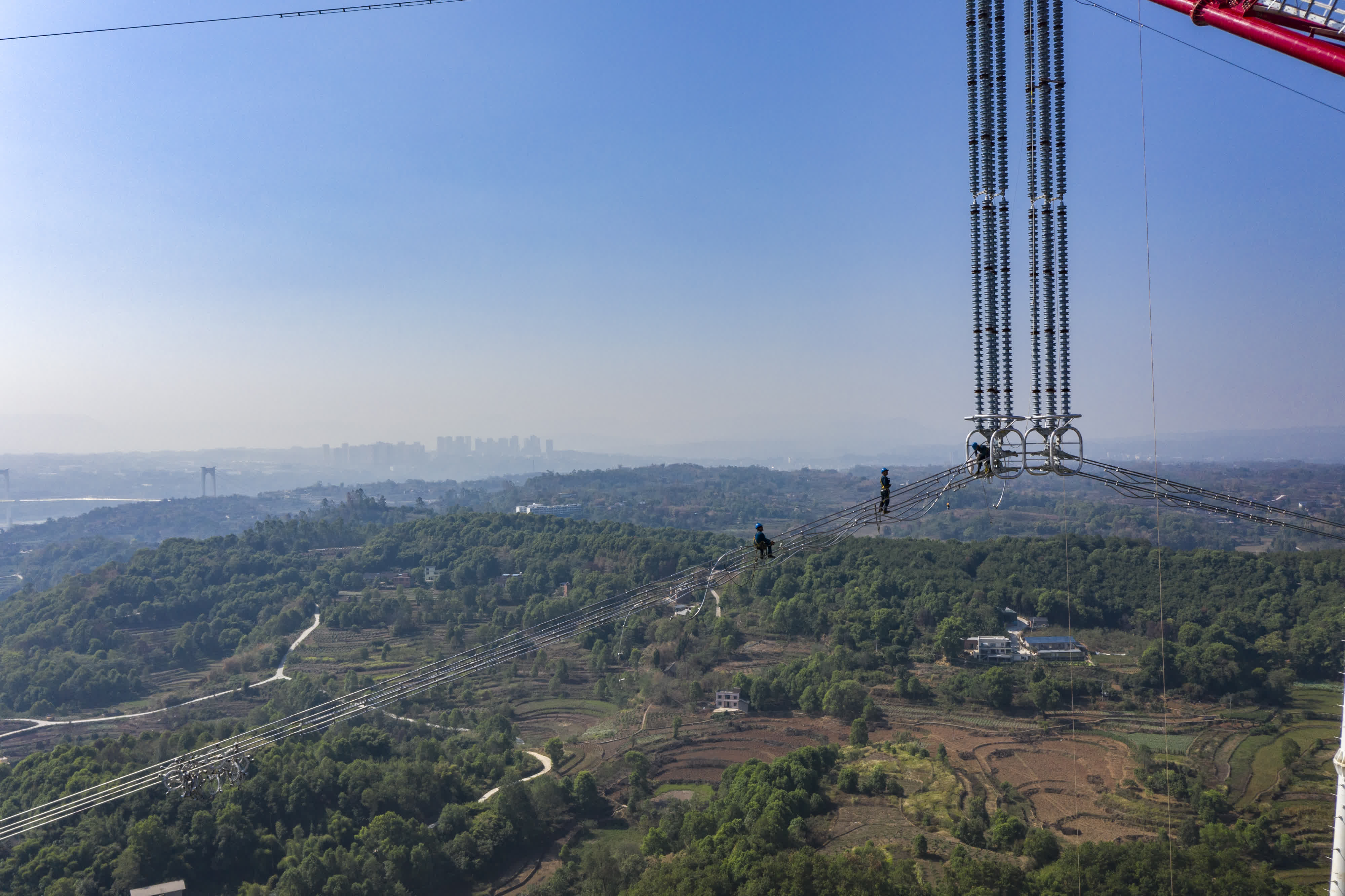 9月13日，工人在白鶴灘-浙江±800千伏特高壓直流輸電線路工程（重慶段）江津長江大跨越施工現場作業。（新華社）