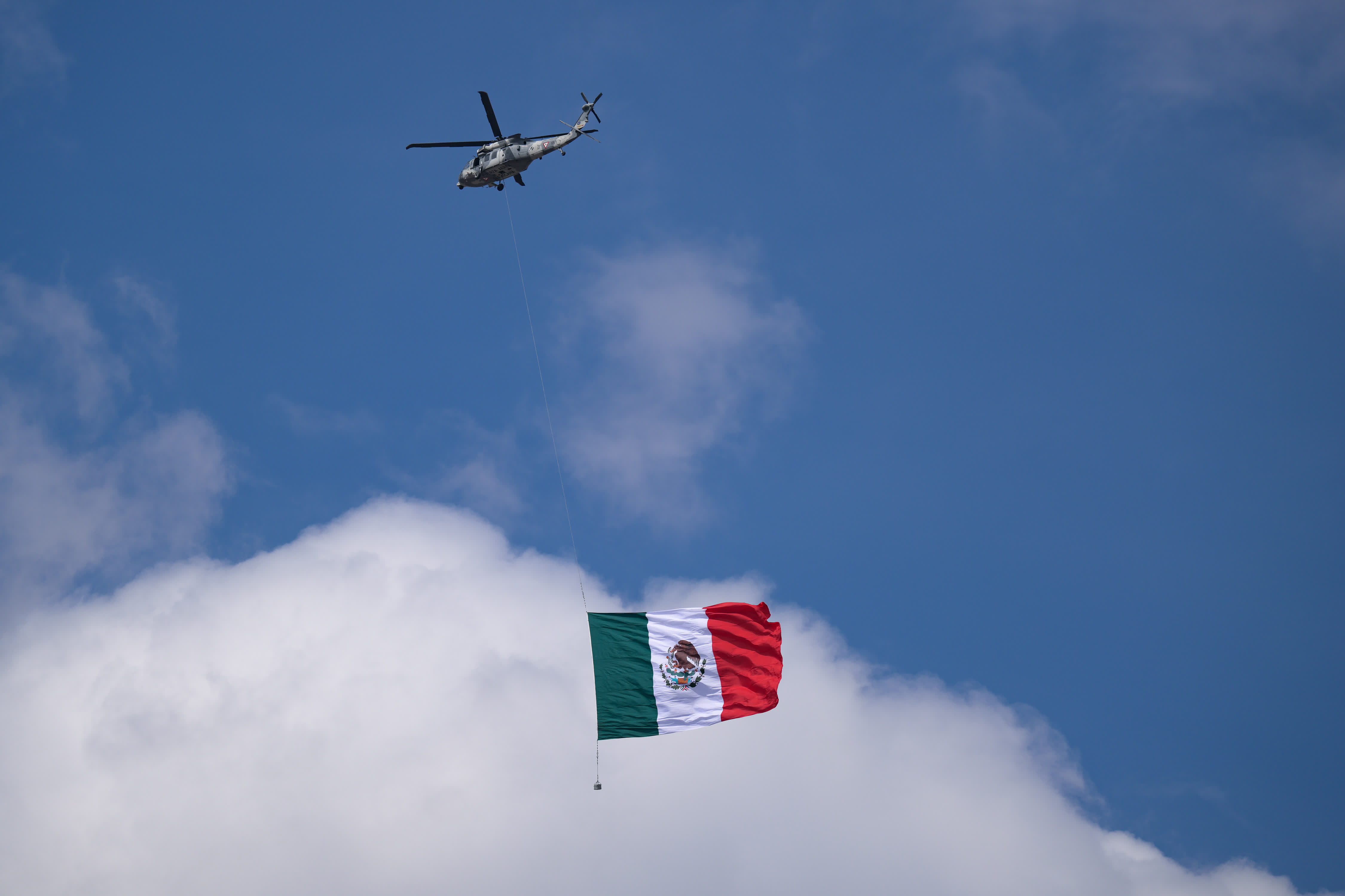 直升機在獨立日閱兵式上展示墨西哥國旗。（新華社）