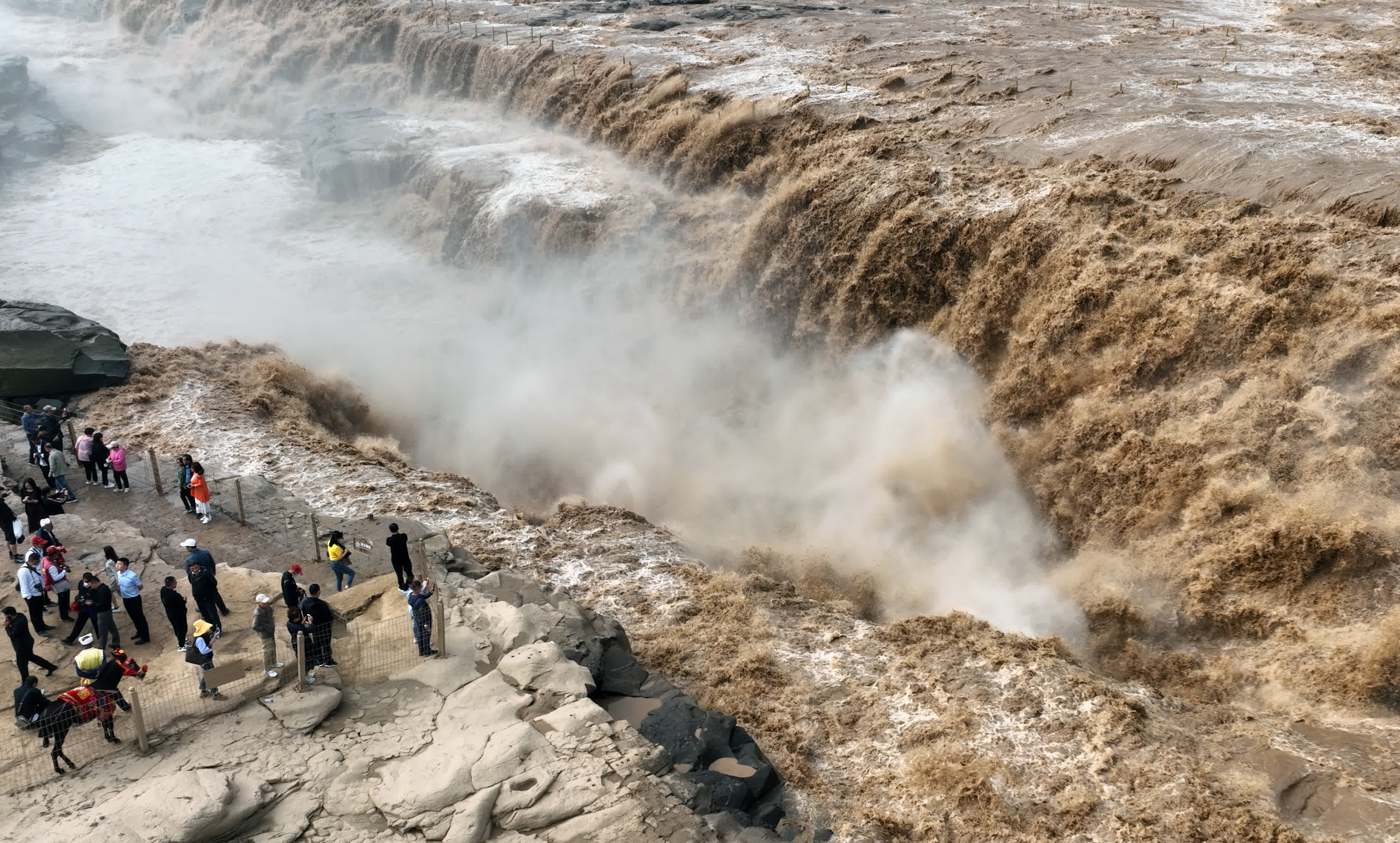 9月15日，遊人在觀賞黃河壺口瀑布群（無人機照片）。（新華社）