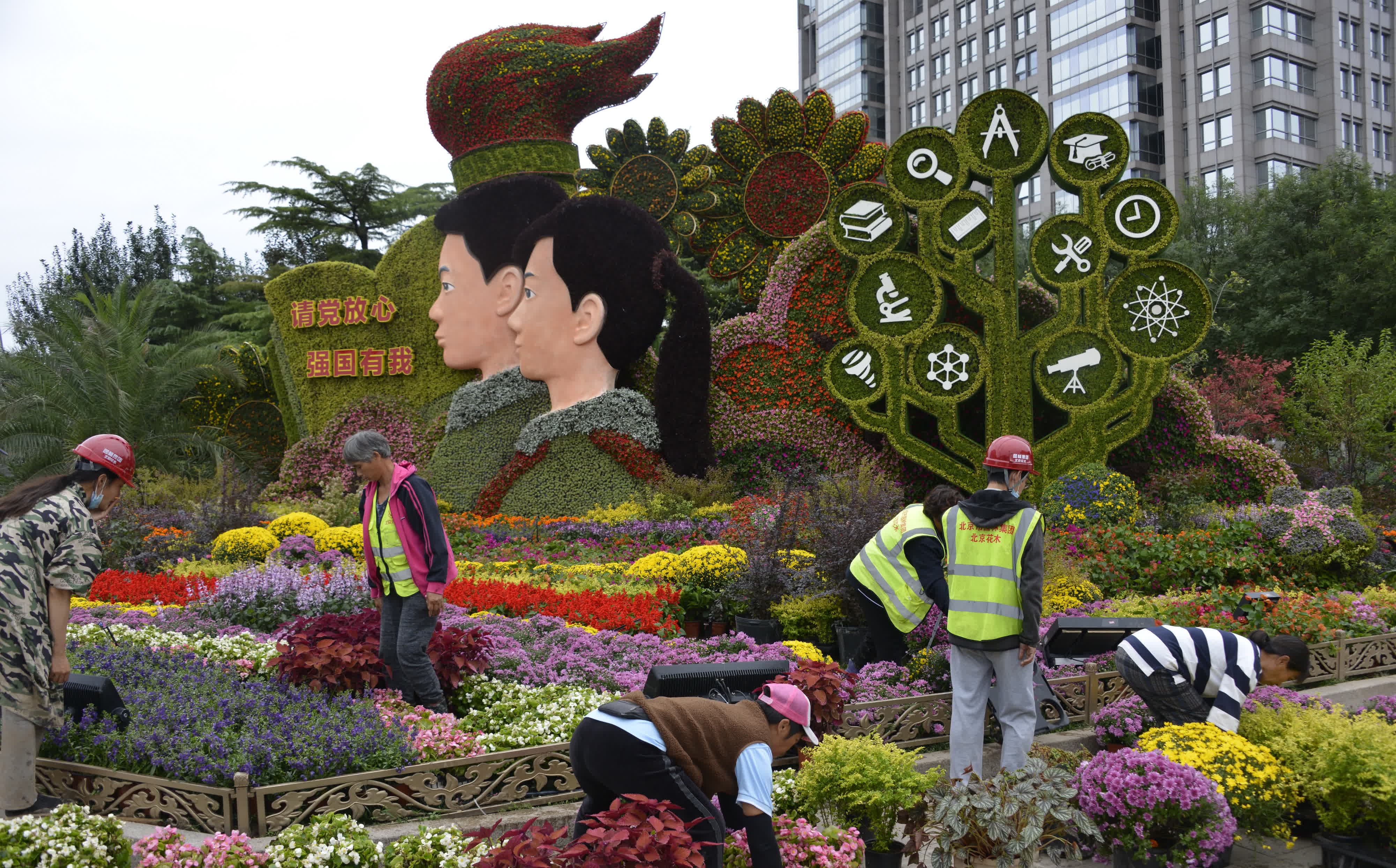 9月25日，園林工人對北京長安街東單路口的主題花壇進行最後修飾。（新華社）