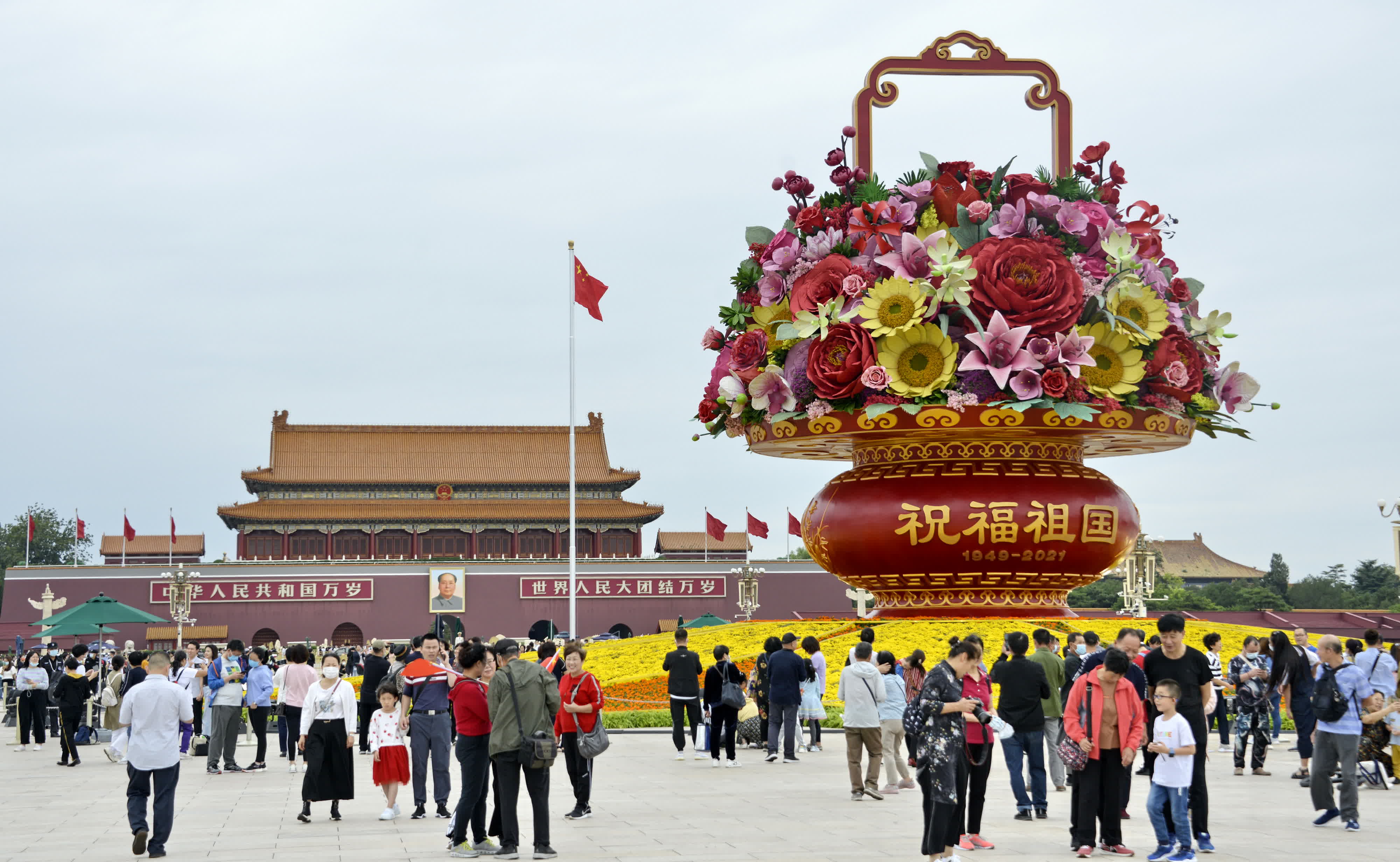 9月25日，遊人和市民在天安門廣場觀賞18米高的「祝福祖國」巨型花籃。（新華社）