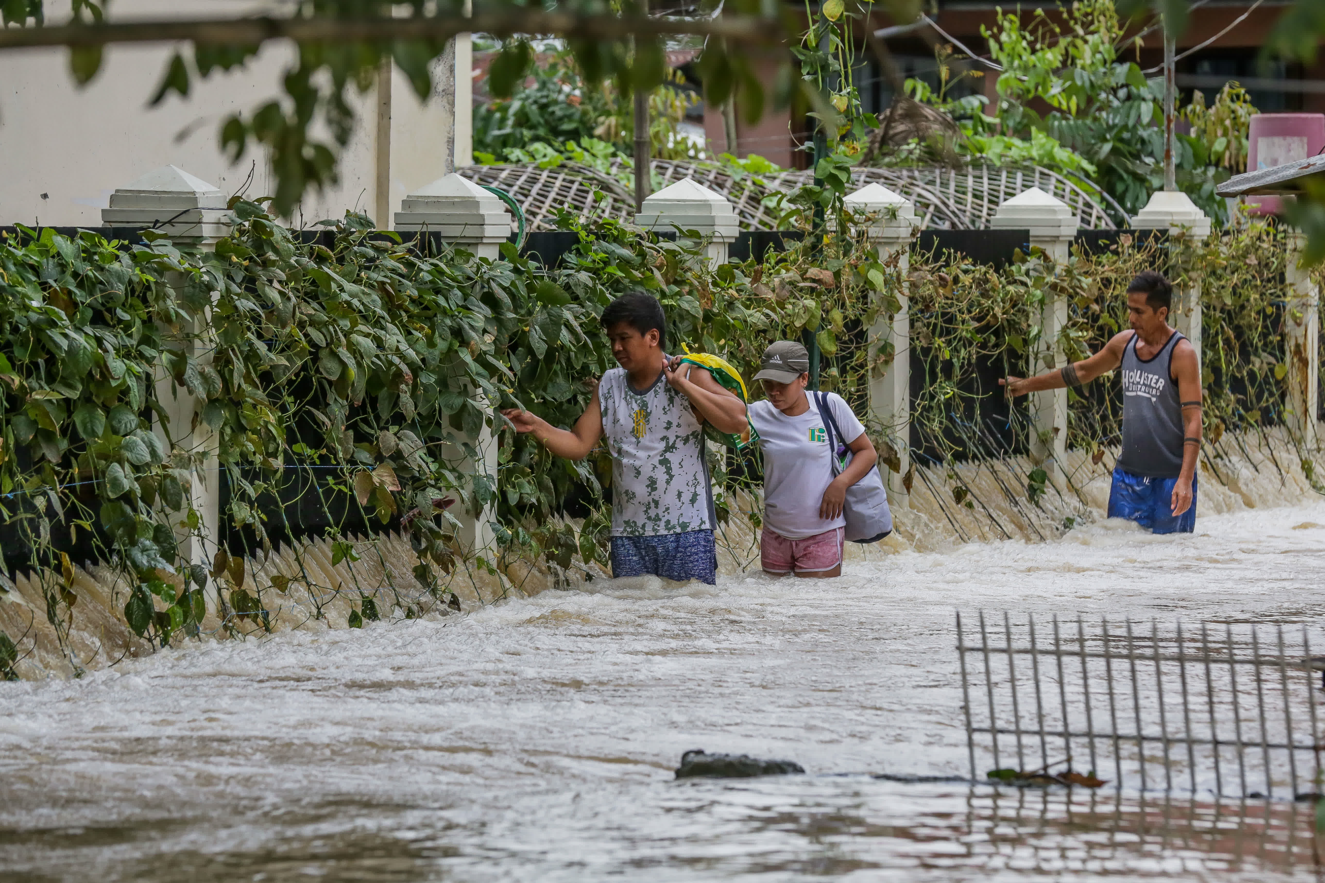 9月26日，在菲律賓布拉干省，人們涉水出行。（新華社）