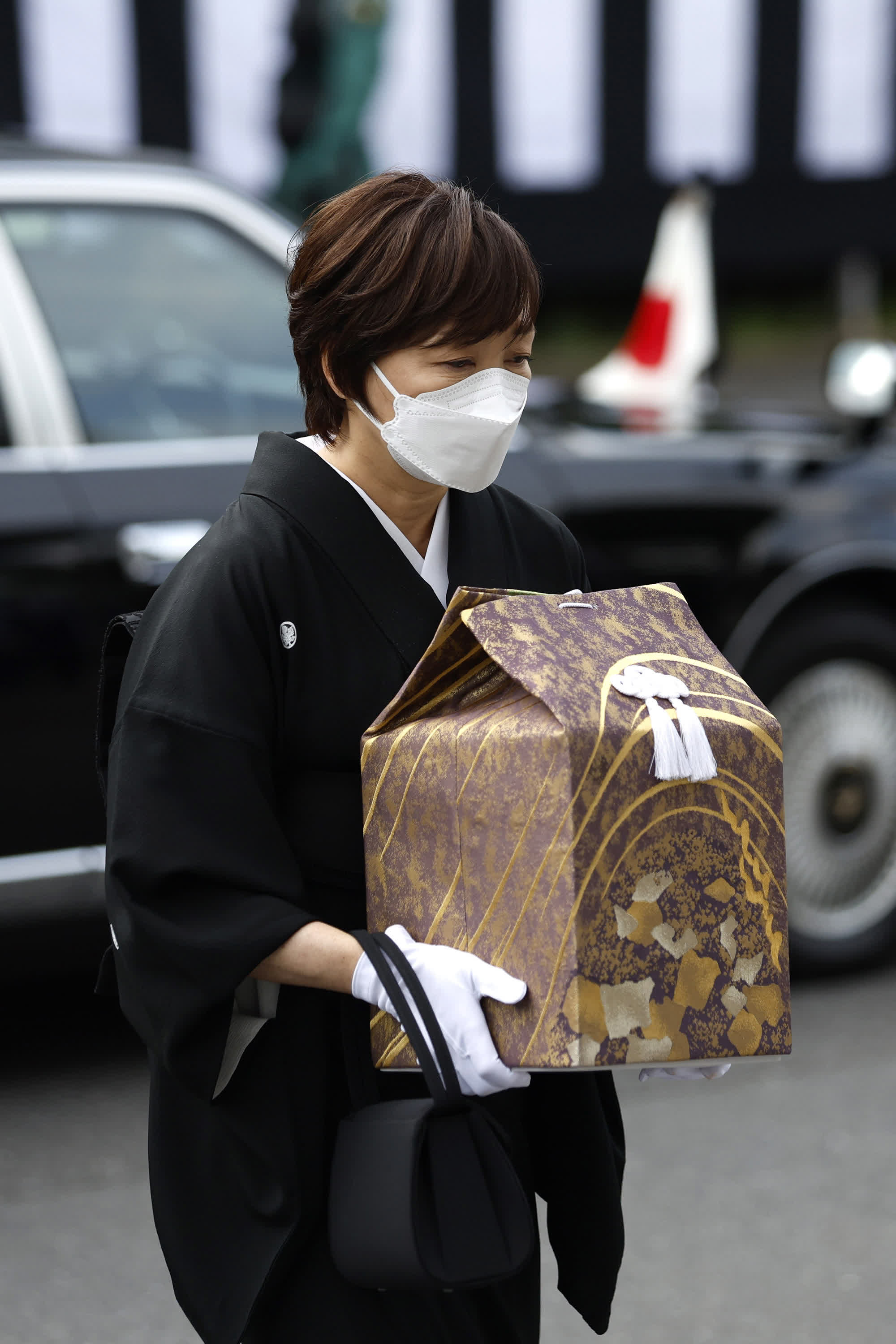 9月27日，在位於東京的日本武道館，日本前首相安倍晉三的夫人安倍昭惠手捧骨灰盒進入國葬儀式現場。（新華社）