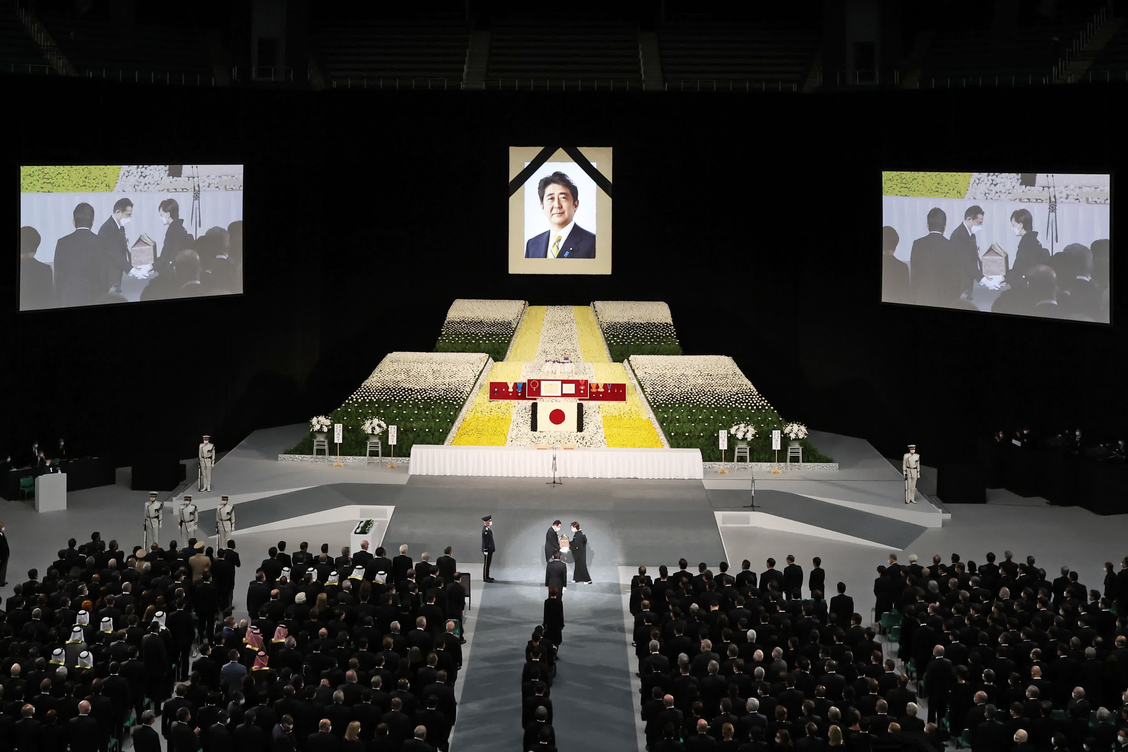 9月27日，在位於東京的日本武道館，安倍晉三的夫人安倍昭惠手捧骨灰盒進入現場。（新華社）