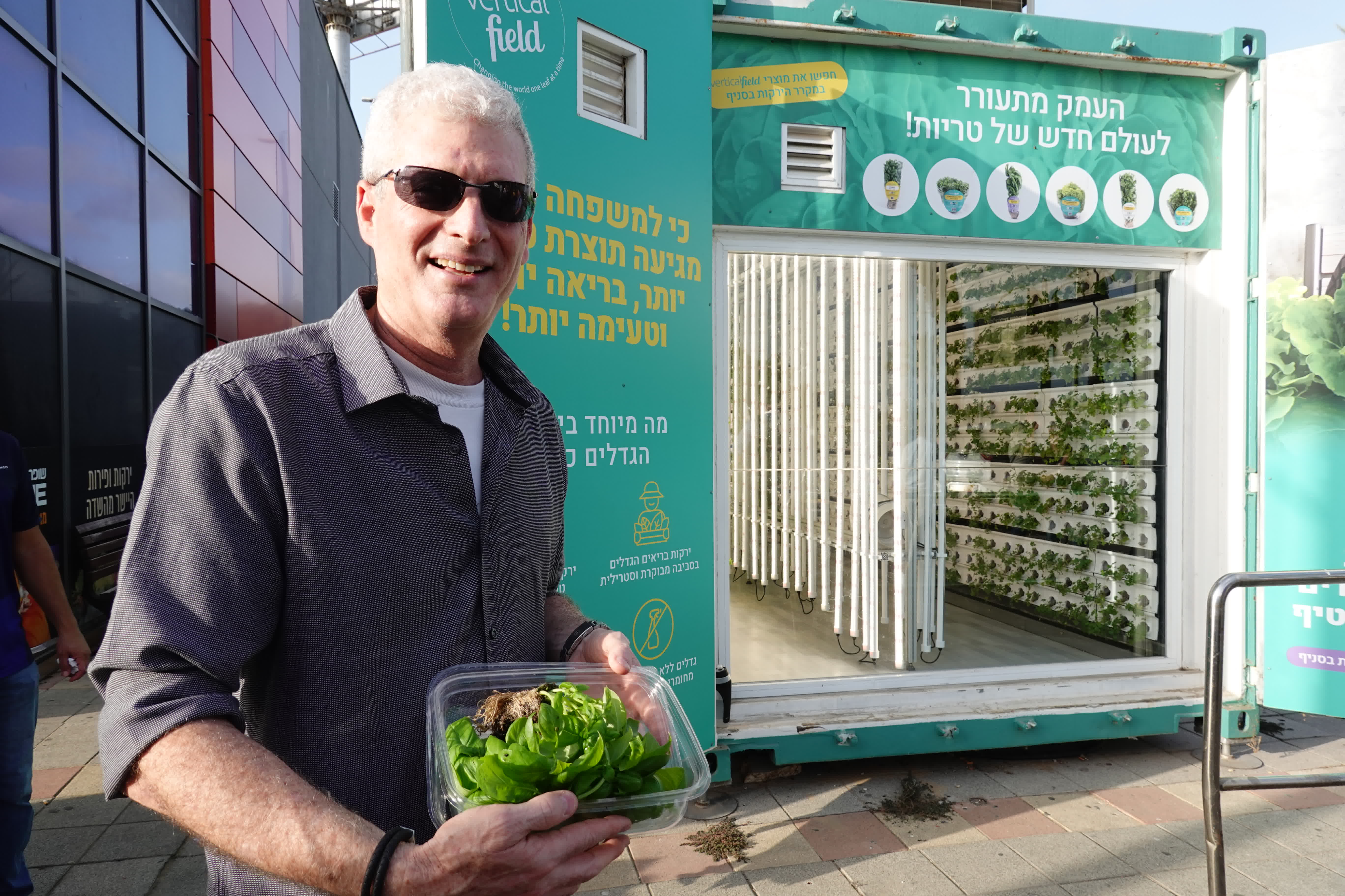 10月3日，一名工作人員在以色列中部城市內坦亞一家超市旁的「垂直農場」外展示收穫的蔬菜。（新華社）