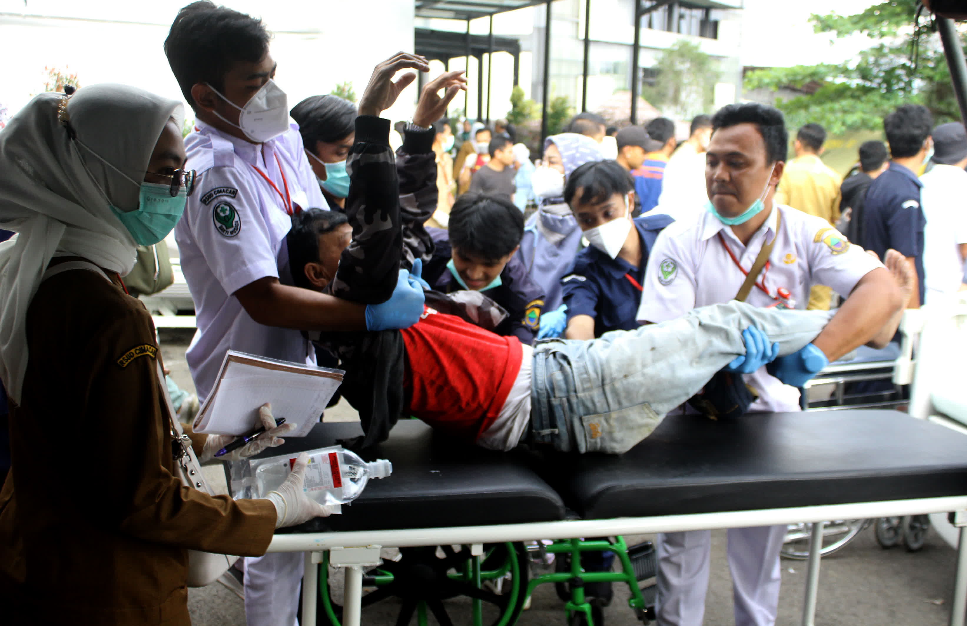 11月21日，醫務人員在印度尼西亞西爪哇省展玉協助轉運傷者。（新華社）